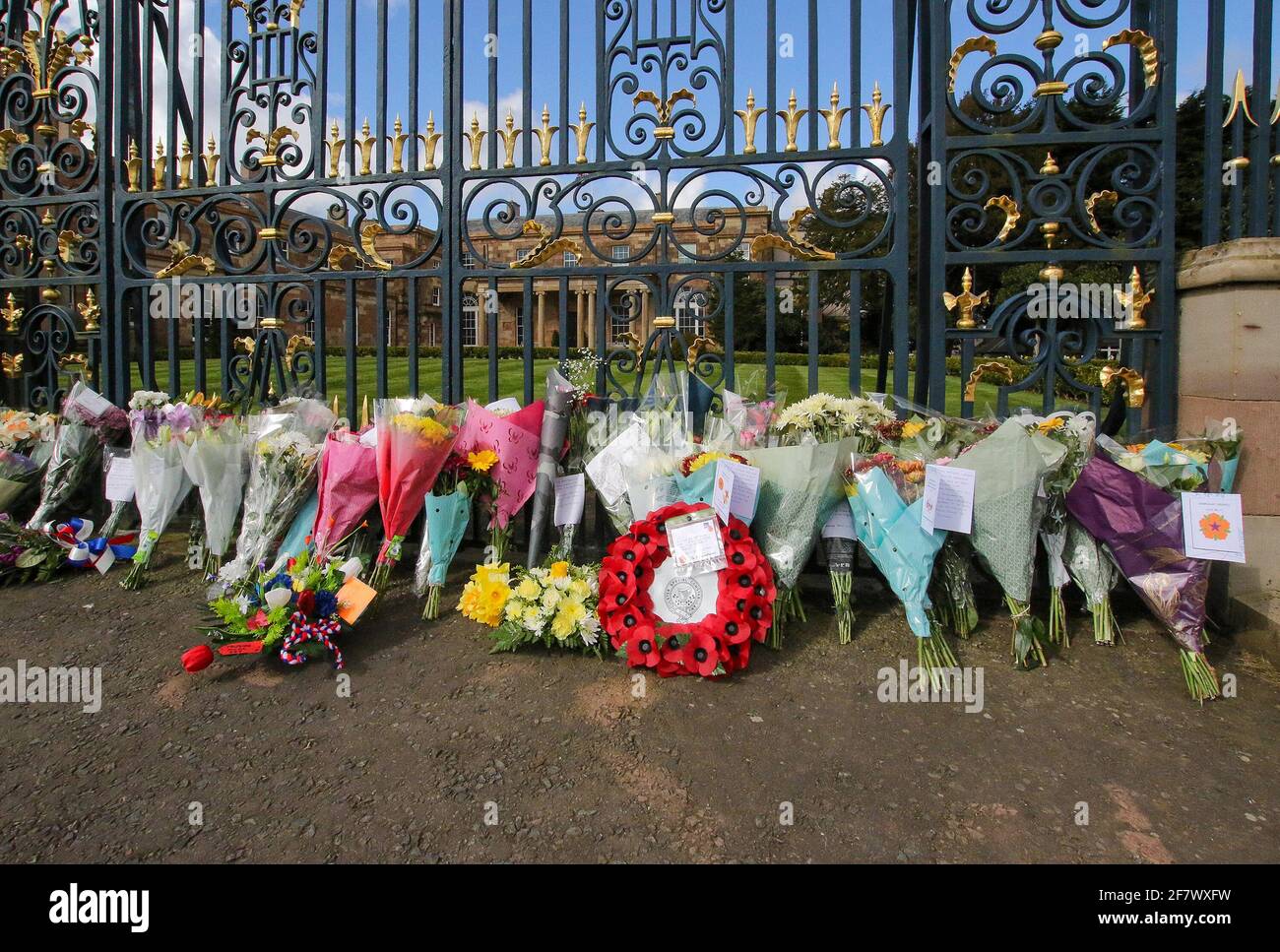 Hillsborough Castle, Hillsborough, County Down, Irlanda del Norte, Reino Unido. 10 de abril de 2021. Con la bandera de la Unión a media asta, se han dejado tributos florales fuera de las puertas de la residencia oficial de HM la Reina en Irlanda del Norte, mientras el público lamenta la pérdida del príncipe Felipe, duque de Edimburgo, que murió ayer. Crédito: David Hunter/Alamy Live News. Foto de stock