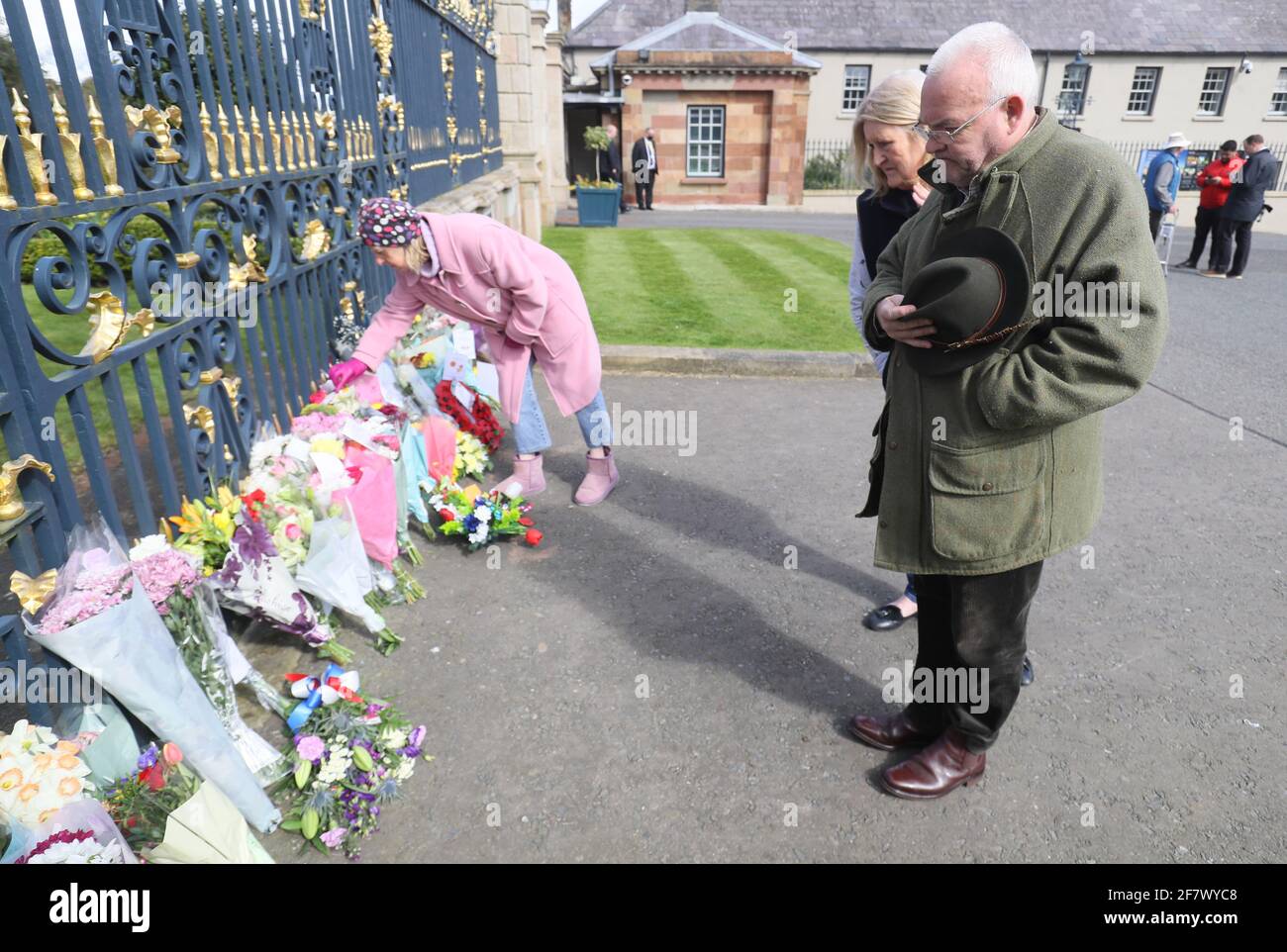 Los miembros del público depositan flores y rinden sus respetos a las puertas del castillo de Hillsborough en Irlanda del Norte, tras el anuncio de la muerte del duque de Edimburgo a la edad de 99 años. Fecha de la foto: Sábado 10 de abril de 2021. Foto de stock