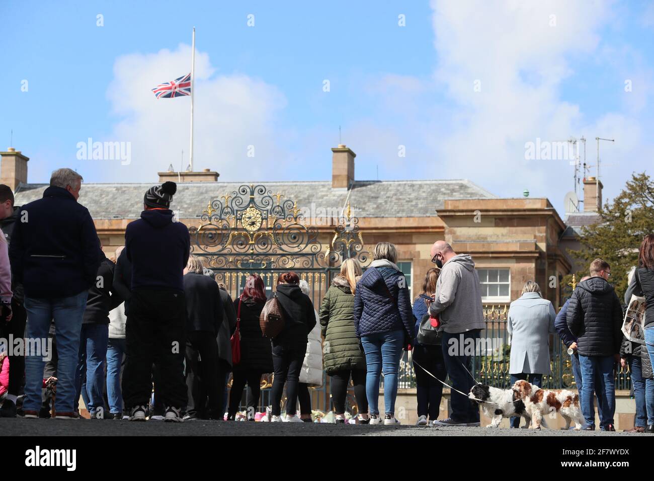 La bandera de la Unión vuela a media asta mientras la gente se reúne para un saludo con arma de 41 vueltas en el Castillo de Hillsborough, Irlanda del Norte, tras el anuncio de la muerte del Duque de Edimburgo a la edad de 99 años. Fecha de la foto: Sábado 10 de abril de 2021. Foto de stock