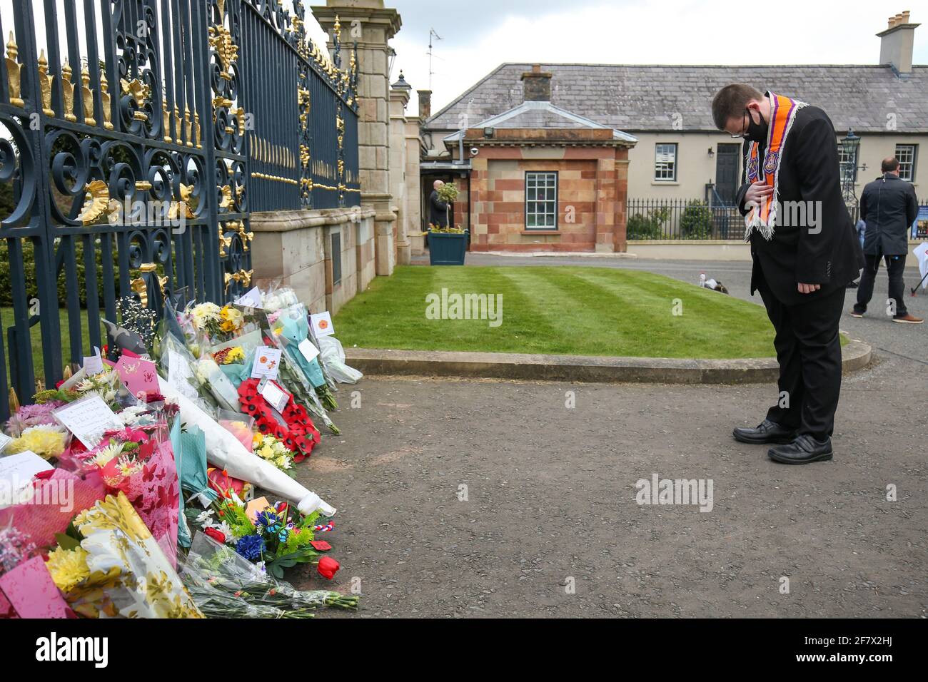Un hombre se arquea delante de las flores colocadas en el Castillo de Hillsborough después de que el Príncipe Felipe de Gran Bretaña, esposo de la Reina Isabel, murió a la edad de 99 años, en Hillsborough, Irlanda del Norte, 10 de abril de 2021. REUTERS/Jason Cairnduff Foto de stock