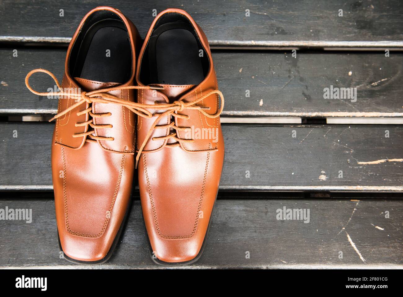 atlántico Infidelidad Mirar fijamente Vista superior de zapatos de piel marrón con cordones amarrados en un arco  sobre un fondo de madera oscura Fotografía de stock - Alamy