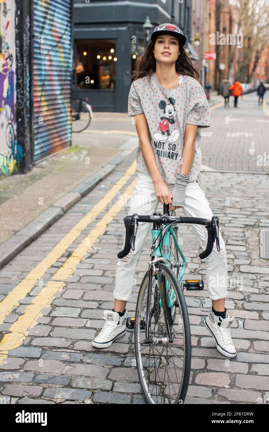 Adolescente sentada en bicicleta en un ambiente urbano en Londres , Reino Unido . Foto de stock