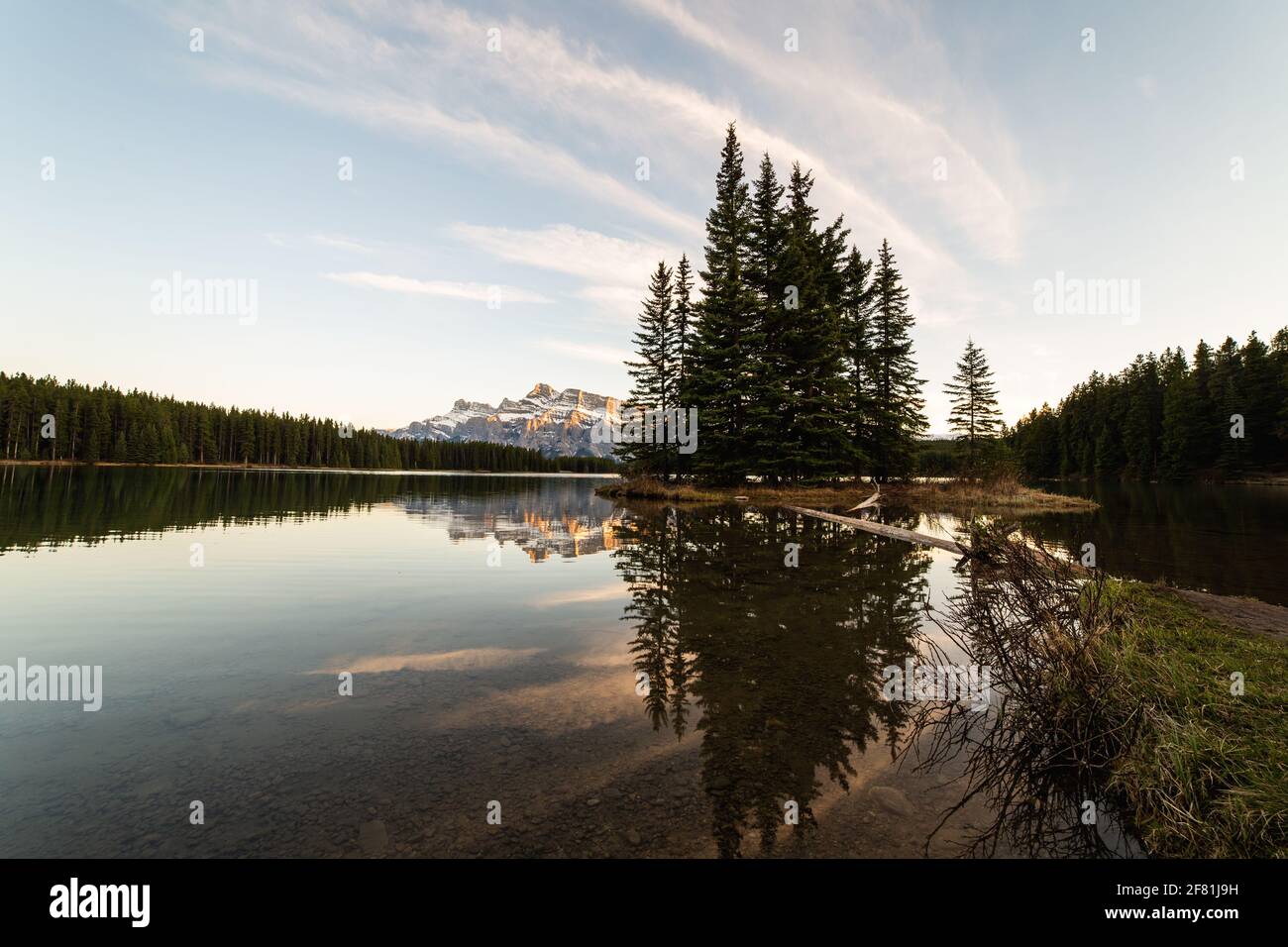 amplia vista angular de un paisaje matutino en las montañas con pino que se refleja en el agua Foto de stock