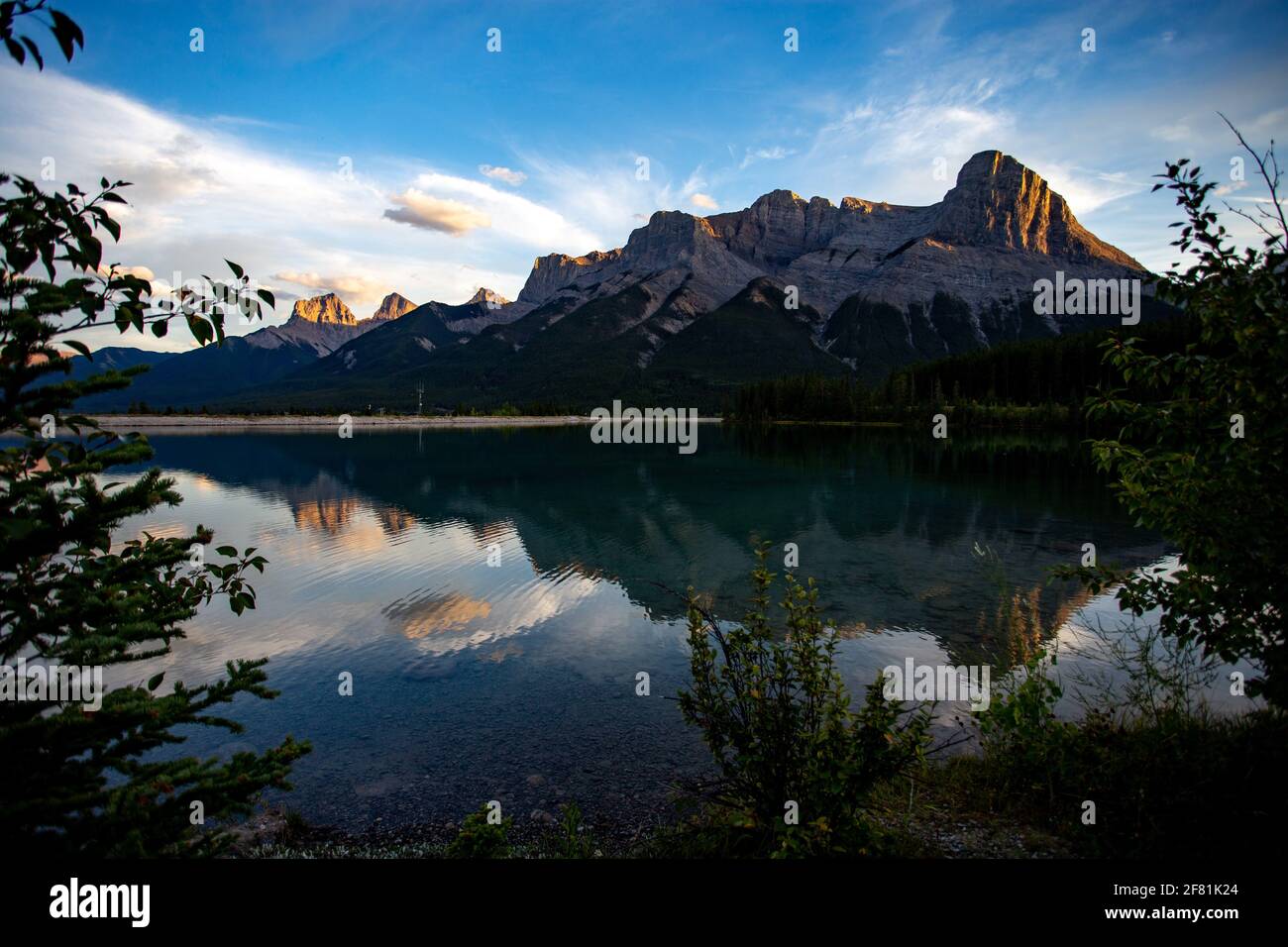 Montaña que se refleja en las aguas tranquilas de abajo en un amanecer en verano Foto de stock