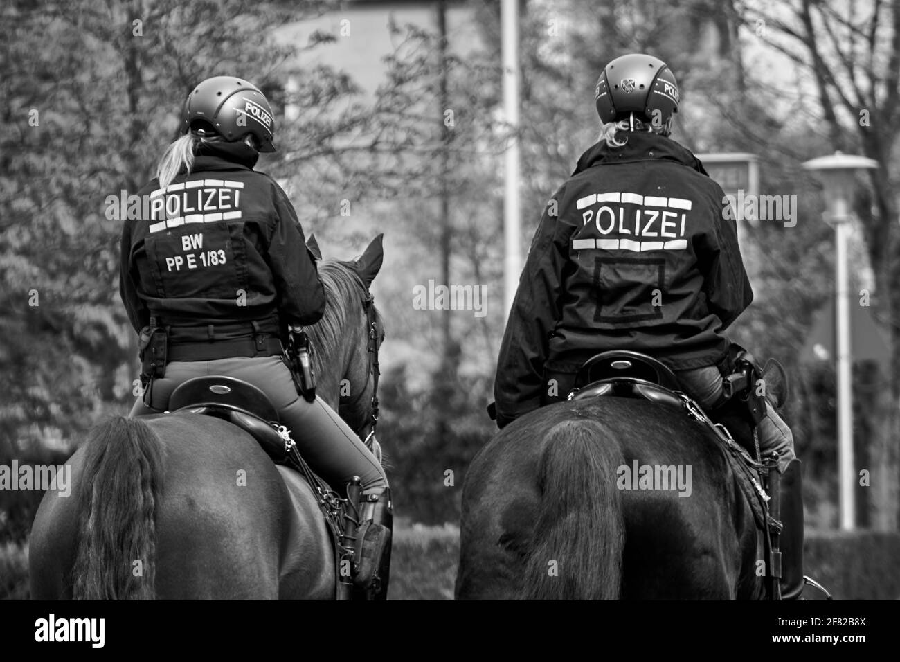 Dos mujeres patrullaron a caballo a la policía durante las protestas contra las restricciones pandémicas del covid-19. Foto de stock