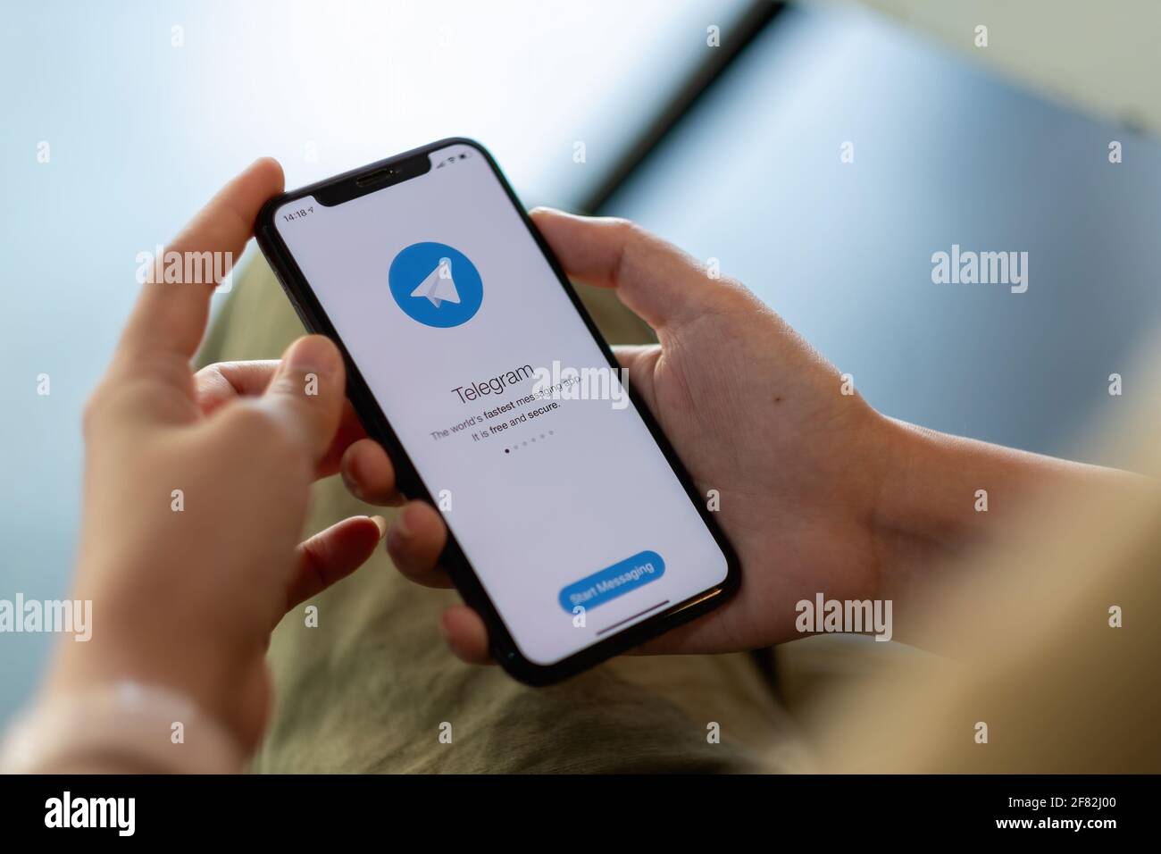 CHIANG MAI, TAILANDIA - 11 DE ABRIL de 2021: Mujer de la mano que sostiene iPhone X con el servicio de redes sociales Telegram en la pantalla. IPhone 10 fue creado y. Foto de stock