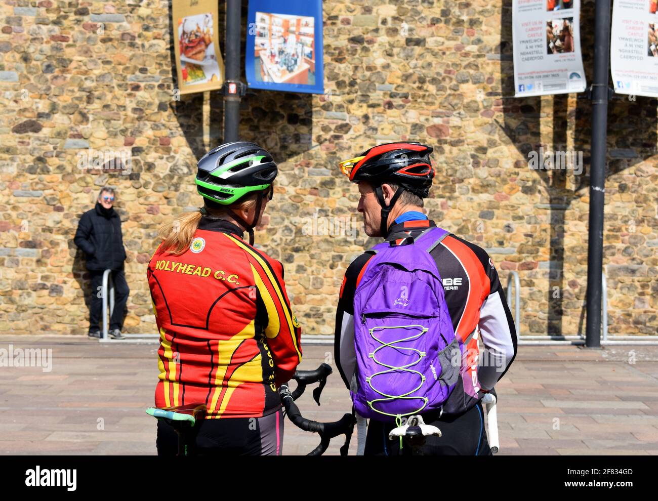 Par de ciclistas esperando fuera del Castillo de Cardiff para el homenaje de 41 armas para marcar la muerte del Príncipe Felipe, Cardiff, Gales Foto de stock