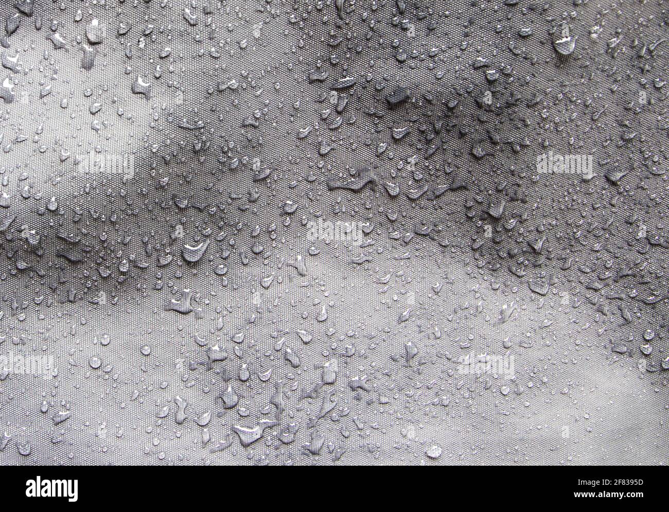 Tejido de nylon gris impermeable cubierto con gotas de agua después de la lluvia Foto de stock