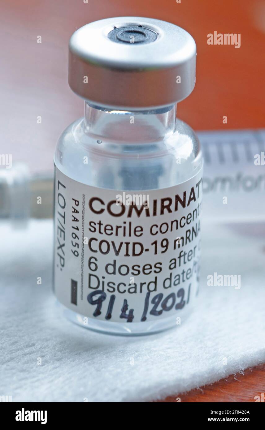 Génova, Italia -Abril 2021, Comirnaty, vacuna de ARN contra covid-19, desarrollada por Pfizer BioNTech sobre fondo rojo Foto de stock