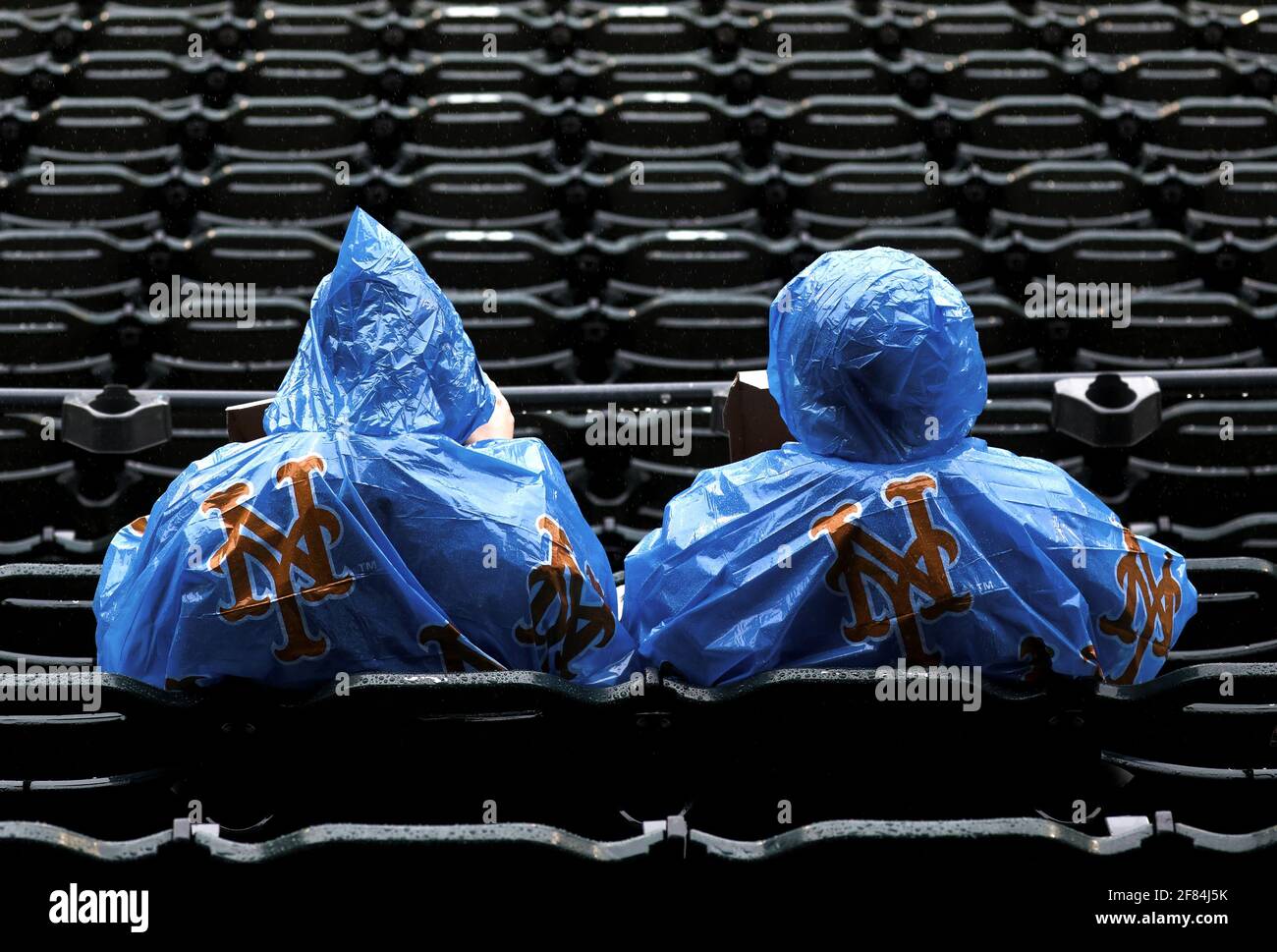 Queens, Estados Unidos. 11th de Abr de 2021. Los fans de los New York Mets se encubren en plástico cuando la lluvia cae en la primera entrada contra los Miami Marlins en Citi Field el domingo, 11 de abril de 2021 en la ciudad de Nueva York. Foto de Peter Foley/UPI Crédito: UPI/Alamy Live News Foto de stock