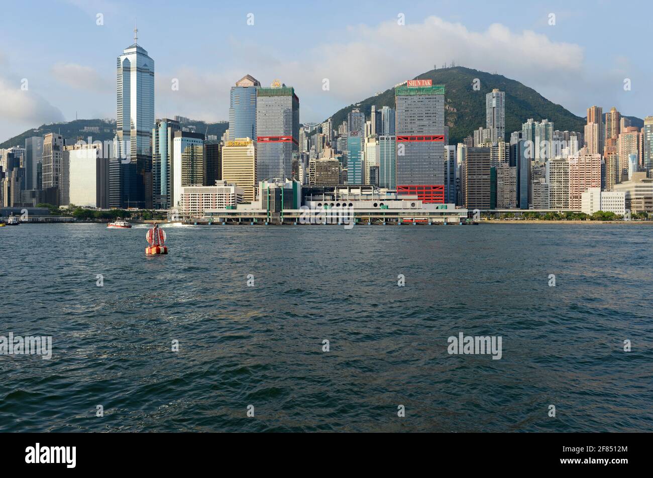 Vista de la costa de la isla de Hong Kong desde el nivel del agua con las  dos torres del centro de Shun Tak prominente. Hong Kong, China Fotografía  de stock -