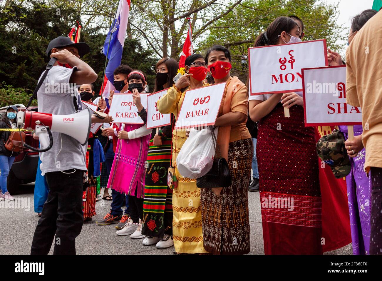 Un organizador encola a representantes de los principales grupos étnicos birmanos a la cabeza de una marcha unida y multiétnica contra el golpe militar en Myanmar. Foto de stock