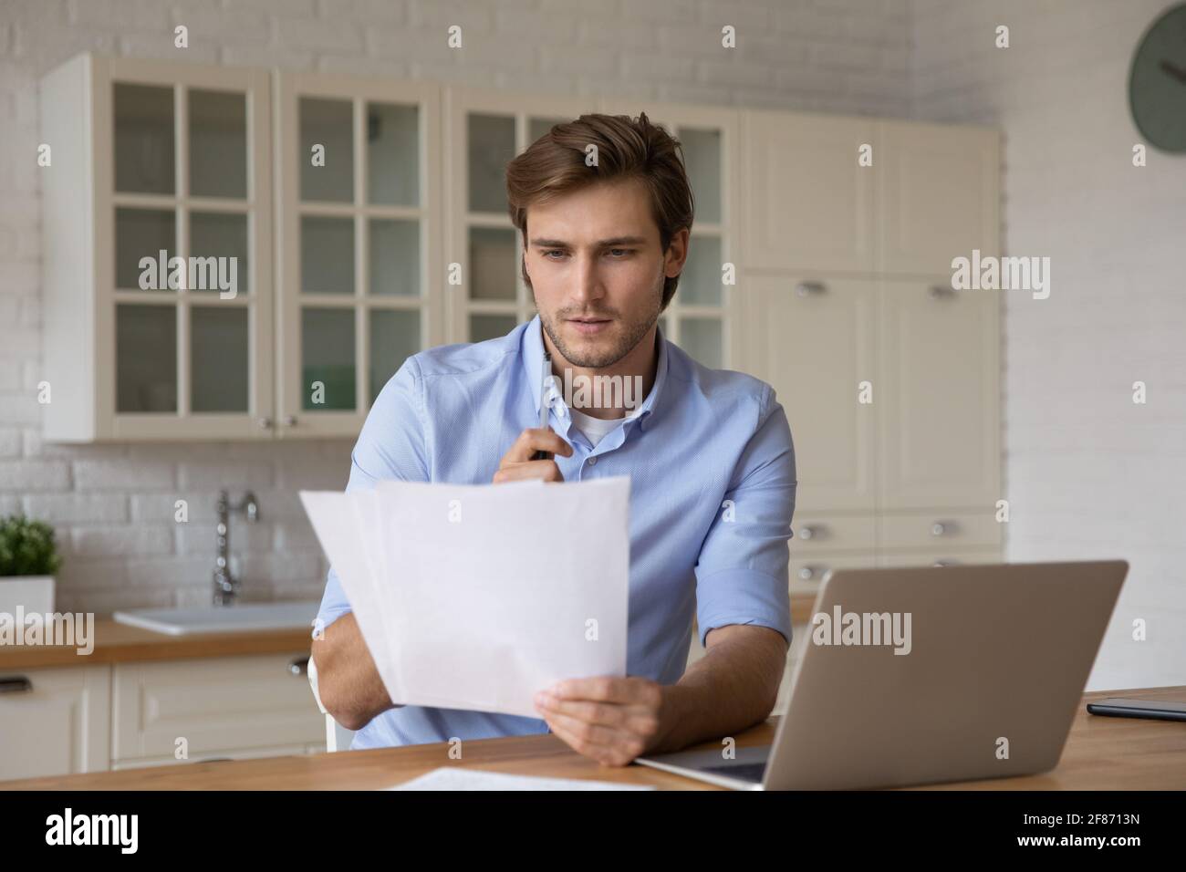 Hombre enfocado leyendo la carta, trabajando con la correspondencia en casa Foto de stock