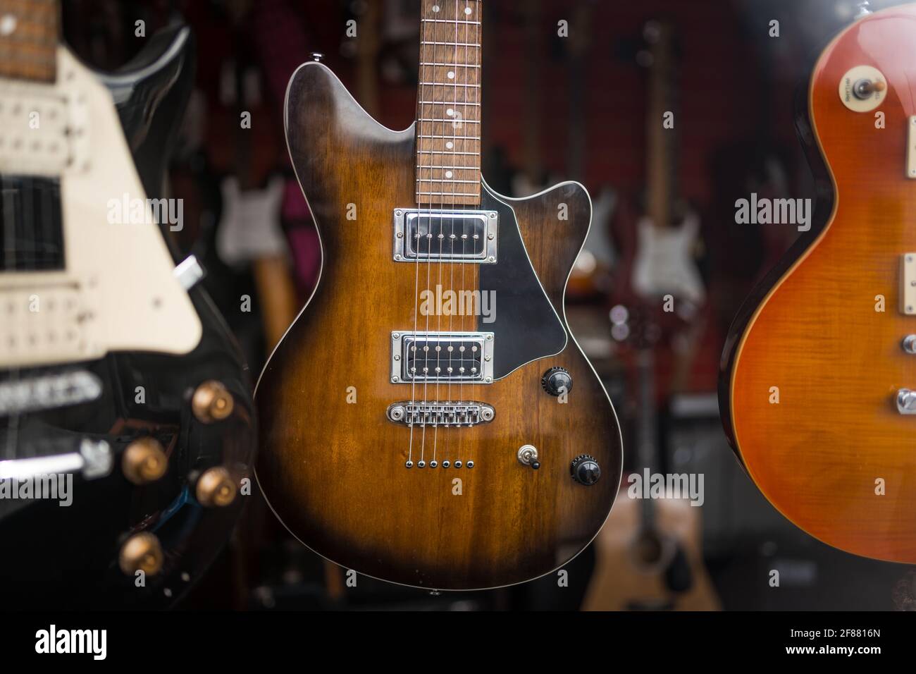 Guitarras eléctricas de segunda mano colgadas en la pantalla en la antigua  ventana de la tienda de instrumentos de segunda mano para la venta  Fotografía de stock - Alamy