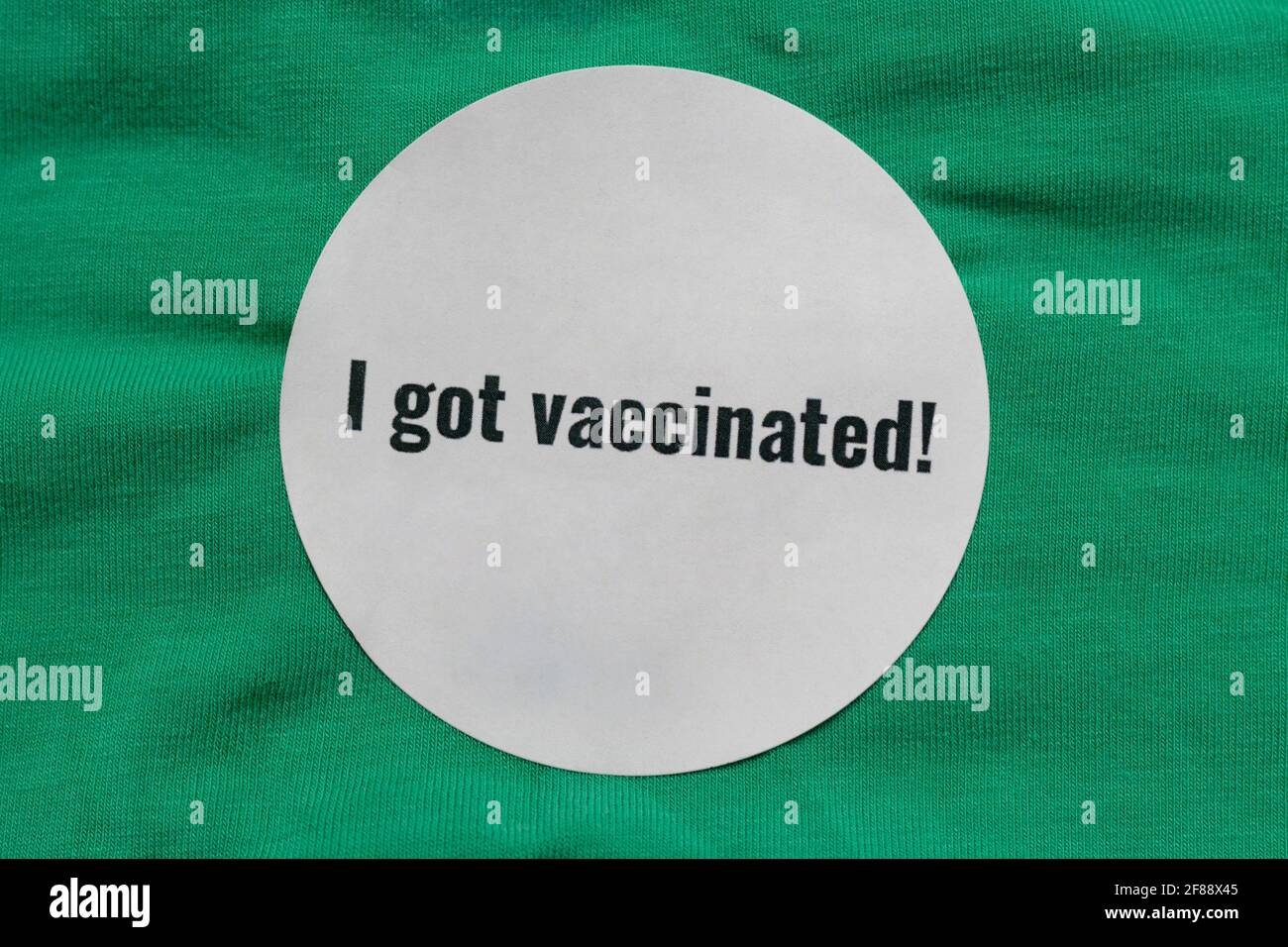 Me dieron una pegatina vacunada a la gente después de recibirla una vacuna covid-19 sobre fondo verde con copia espacio Foto de stock
