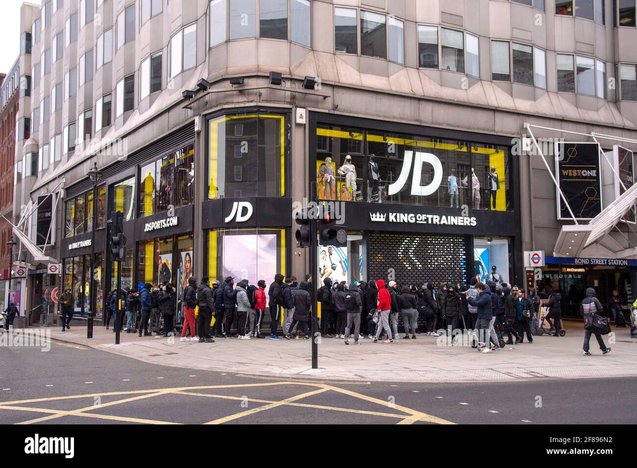 Un gran grupo de compradores espera fuera de la entrada para la tienda JD Sports para abrir en Oxford Street ya que las tiendas no esenciales reabren después del cierre de 4th. Foto de stock