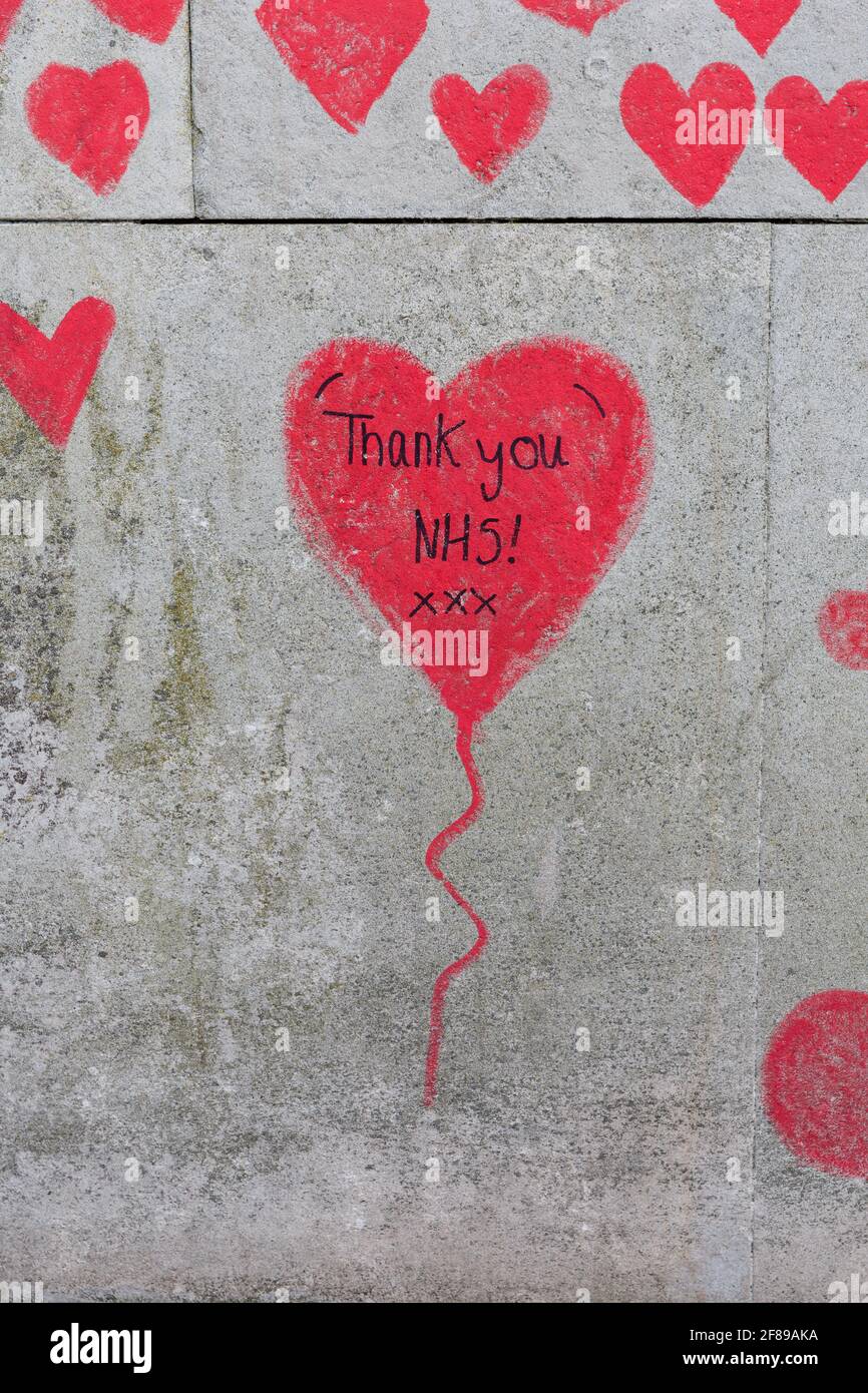 El personal de primera línea del NHS recordó con corazones rojos pintados en el National Covid Memorial Wall, un homenaje a las víctimas británicas de la pandemia de Coronavirus Foto de stock