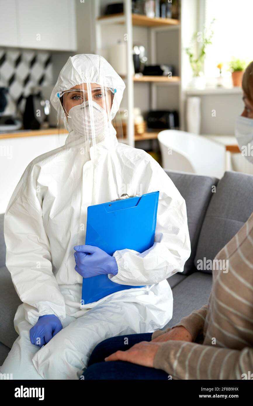Retrato del trabajador de la salud en ropa de trabajo protectora durante un hogar visita Foto de stock