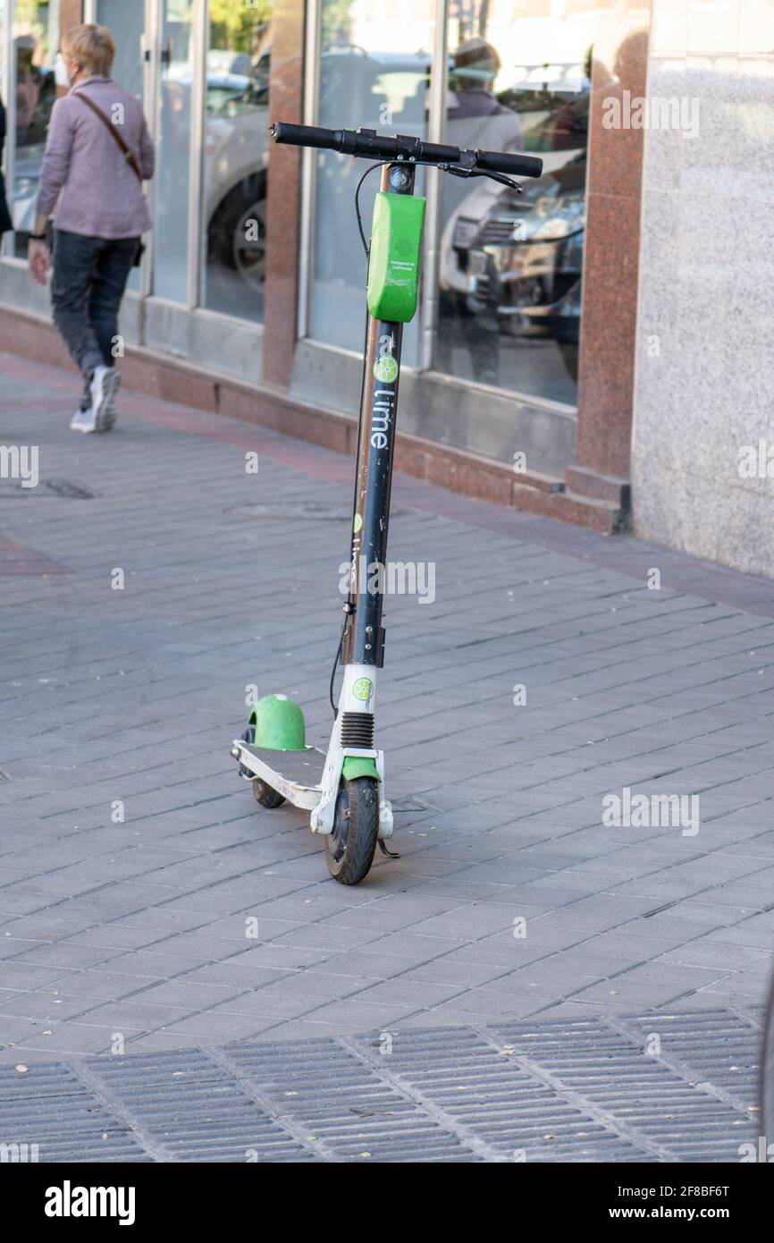 MADRID, ESPAÑA - 07 de abril de 2021: Madrid España. 6 de abril de 2021.  Disparo vertical de una scooter eléctrica para alquilar por minuto con app,  de la empresa Lime Fotografía de stock - Alamy
