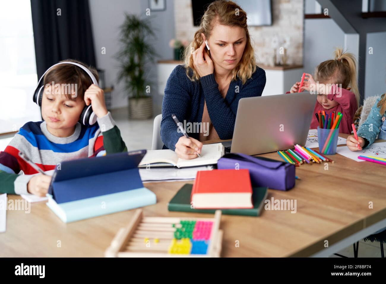 Madre ocupada durante la oficina en casa con niños en casa Foto de stock