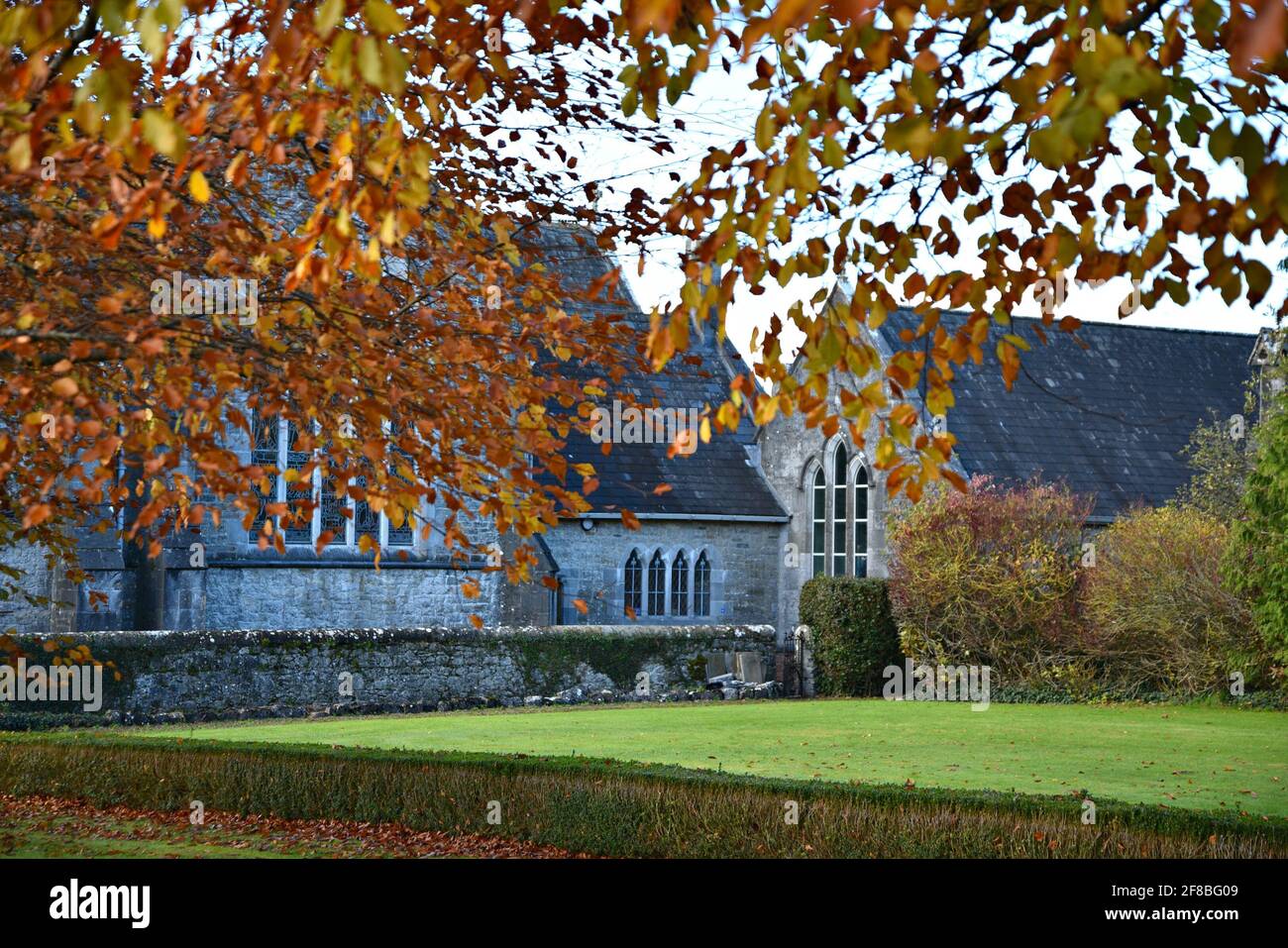 Paisaje con vistas panorámicas de la abadía medieval de estilo gótico renacentista de la Santísima Trinidad en Adare, Limerick, Irlanda. Foto de stock