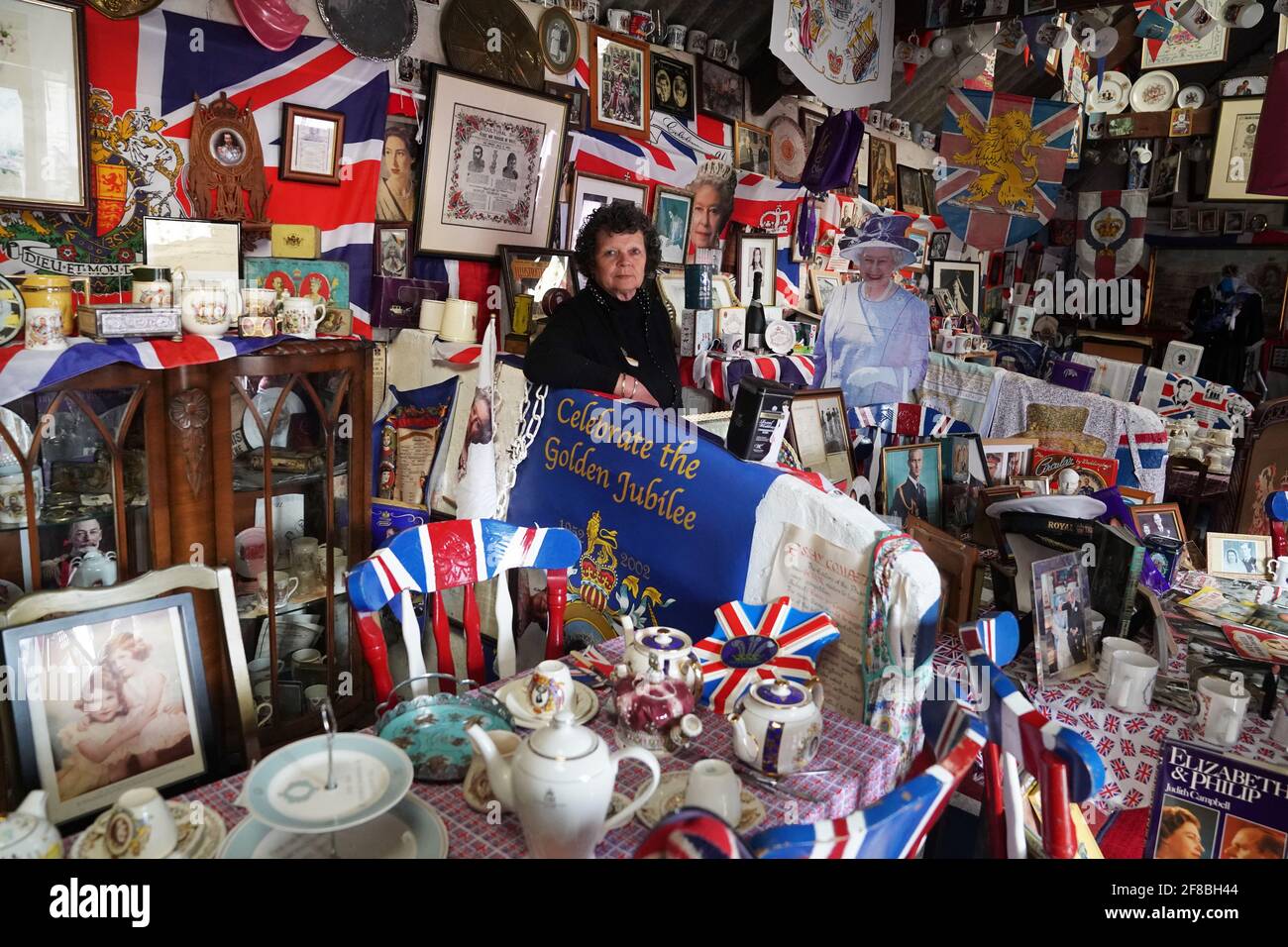 Anita Atkinson arreglando la Reina y la sección del Duque de Edimburgo de su colección real de recuerdos, una de las más grandes del mundo, en su casa en Crook, Condado de Durham. La niña de 64 años dice que fue devastada al escuchar la noticia de la muerte del príncipe Felipe. Fecha de la foto: Martes 13 de abril de 2021. Foto de stock