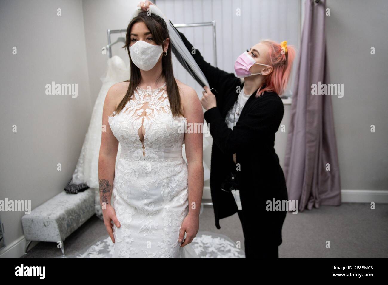 Novia-a-ser Erin Barwell intenta en vestidos por primera vez desde minoristas no esenciales reabiertos esta semana. Erin, de Stoke-on-Trent, se casará el próximo mes de febrero y será juzgado con vestidos en Roberta's Bridal en Burslem, Stoke-on-Trent, tras la mayor relajación de las restricciones de encierro en Inglaterra. Fecha de la foto: Martes 13 de abril de 2021. Foto de stock
