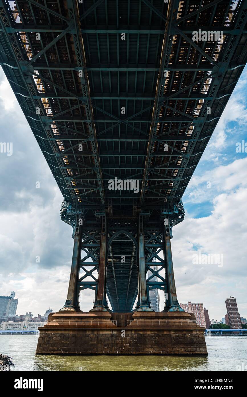 Vista emblemática bajo el puente de Manhattan contra el paisaje urbano de la ciudad de Nueva York. Río Este. Conceptos de Viaje y Transporte Foto de stock
