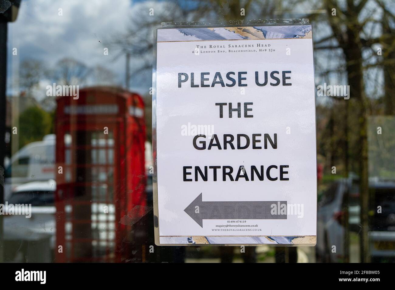 Beaconsifield, Buckinghamshire, Reino Unido. 13th de abril de 2021. Un cartel en el pub Royal Saracens Head que dirige a los clientes al jardín del pub. Pub jardines reabierto a los clientes de antaño. Beaconsfield se estaba volviendo más concurrido hoy cuando la gente estaba fuera disfrutando del sol de primavera y el siguiente paso en la hoja de ruta de alivio de bloqueo Covid-19. Las señales de bienvenida han sido colocadas alrededor de la ciudad por Buckinghamshire Council. Crédito: Maureen McLean/Alamy Live News Foto de stock