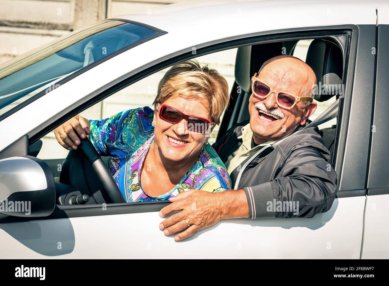 Feliz pareja de personas mayores preparada para conducir un coche en un Viaje viaje - concepto de alegre y activo estilo de vida de los ancianos con el hombre y la mujer disfrutan de su mejor año Foto de stock