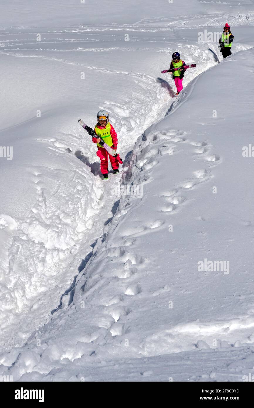 Pequeño niño en ropa de esquí, cascos y gafas, listo para ir a esquiar con  la caída de nieve Fotografía de stock - Alamy
