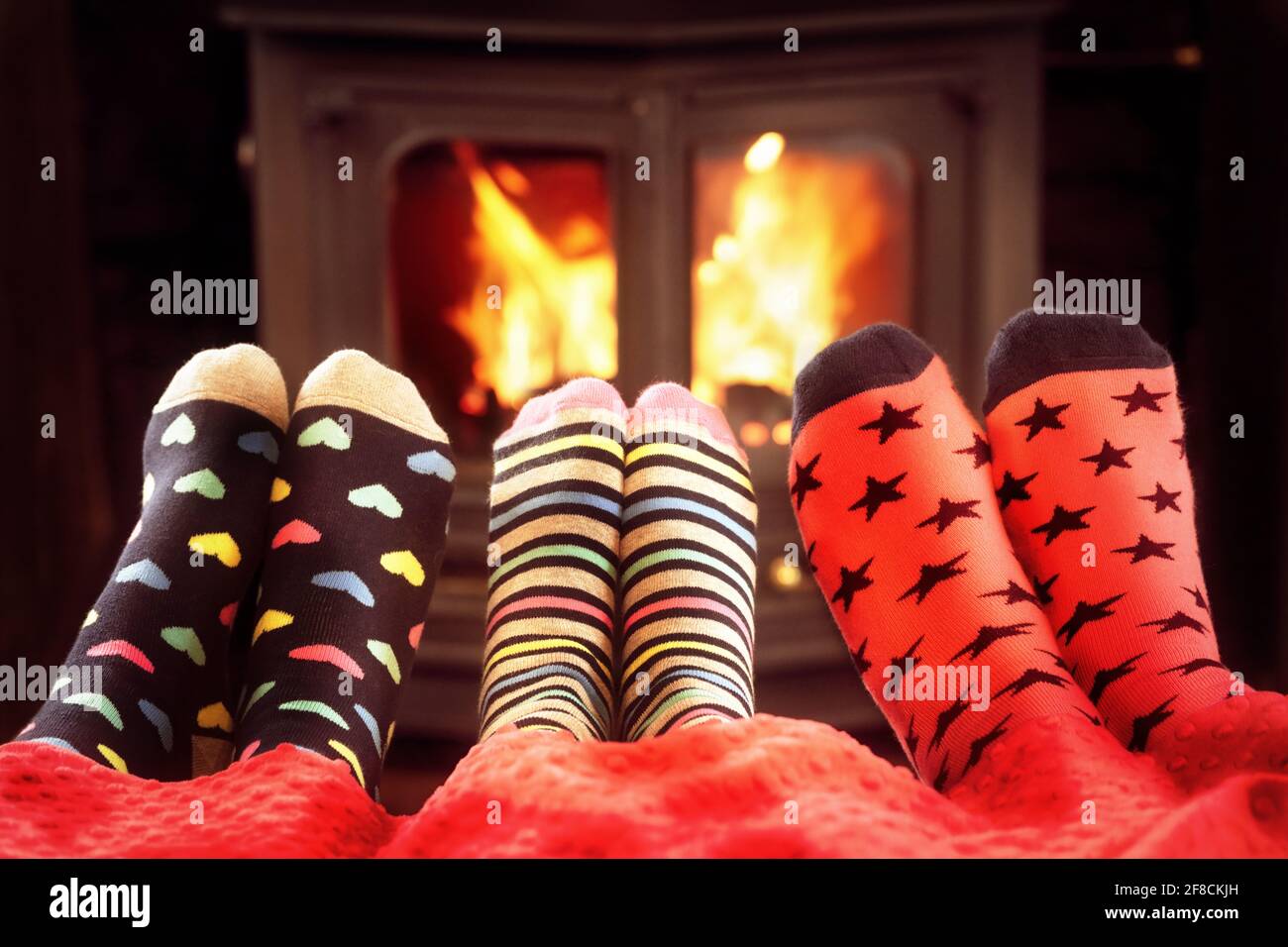 Pies en calcetines de lana cerca de la chimenea en invierno Foto de stock