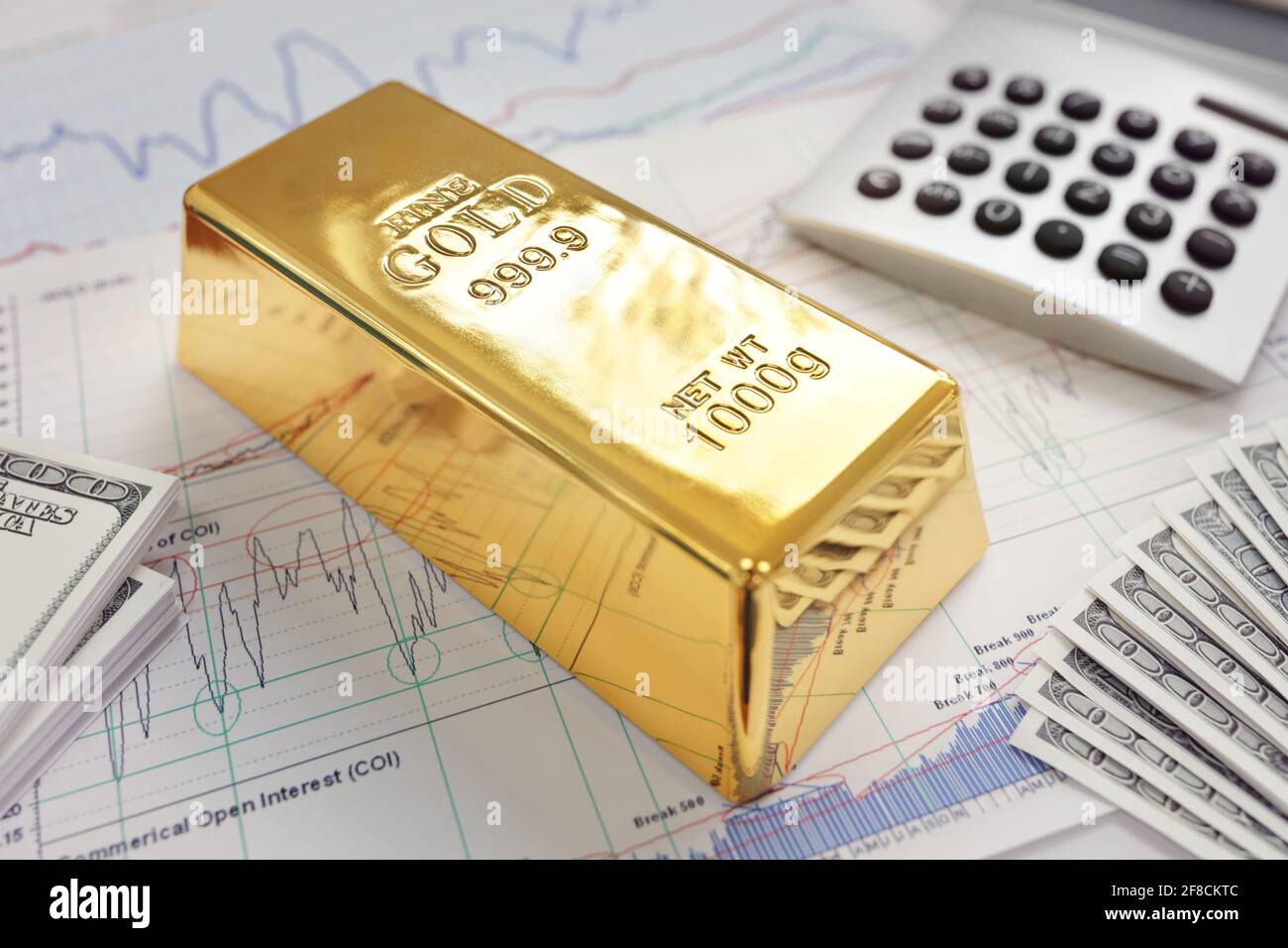 Lingote de oro apoyado en un gráfico de acciones y acciones que representa inversión o banca Foto de stock