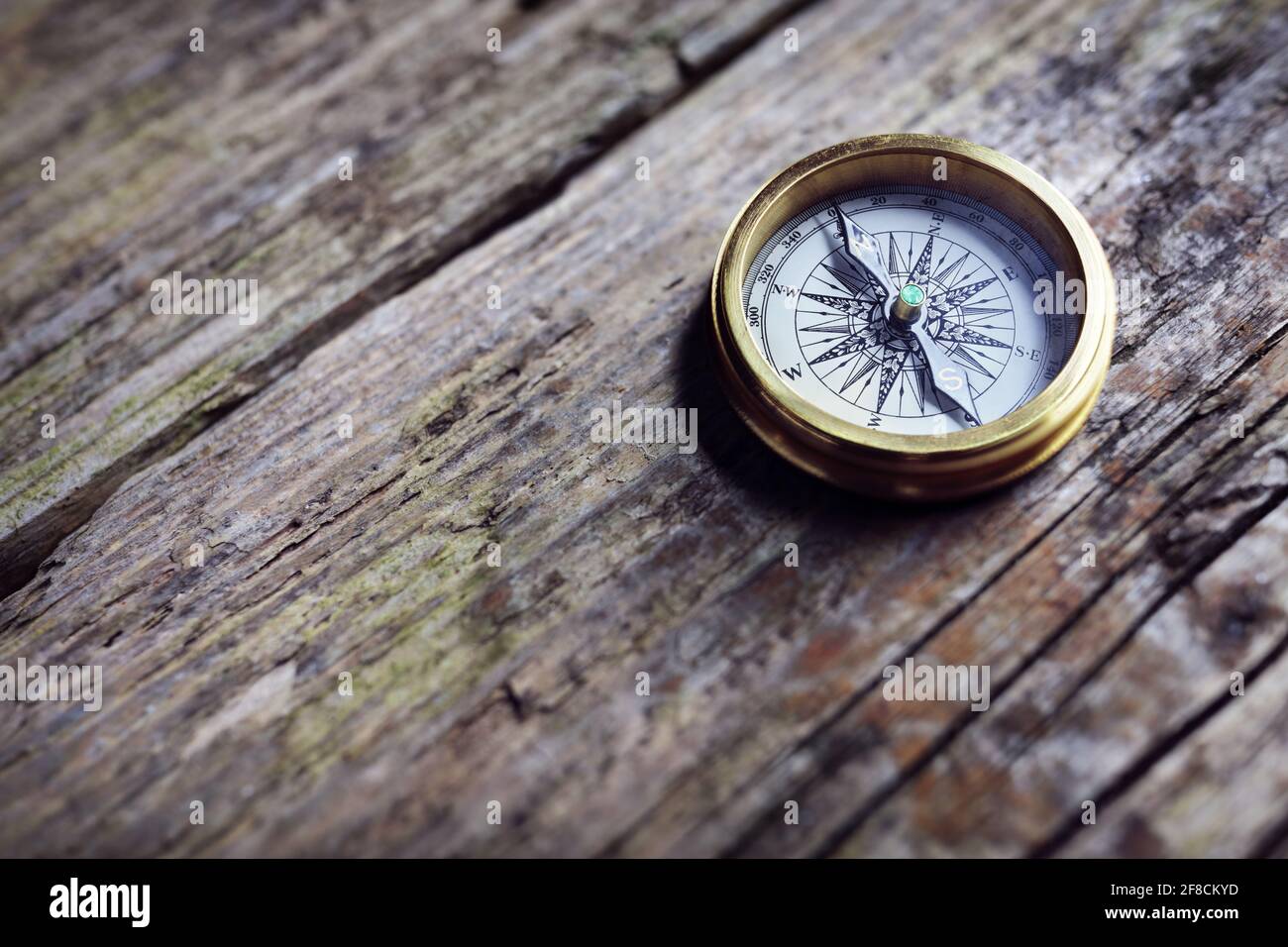 Brújula dorada antigua sobre el fondo de madera concepto de dirección, viajes, orientación o asistencia Foto de stock