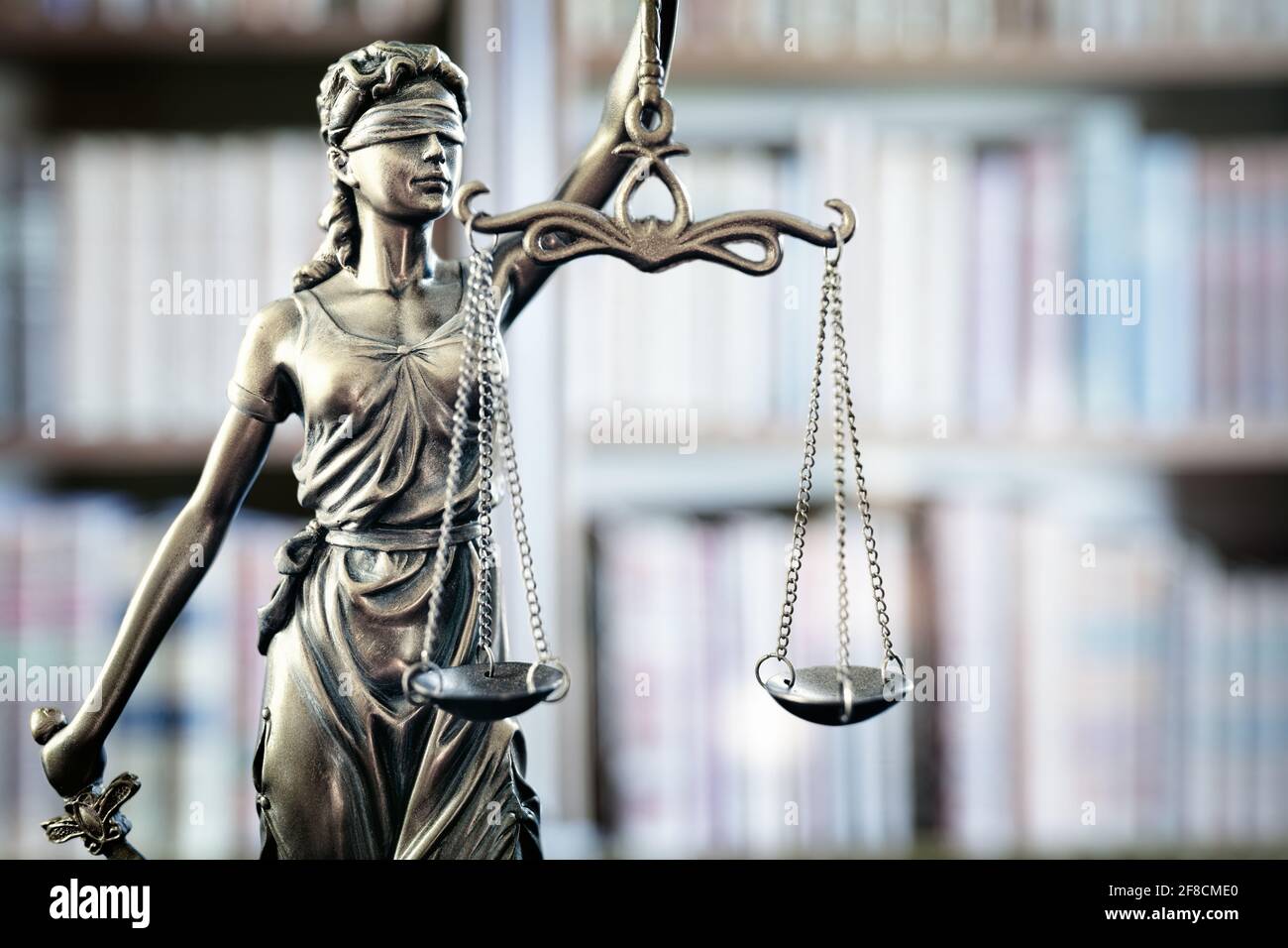 Estatua legal y legal de la escala de justicia de Lady Justice y libros de derecho en la estantería Foto de stock
