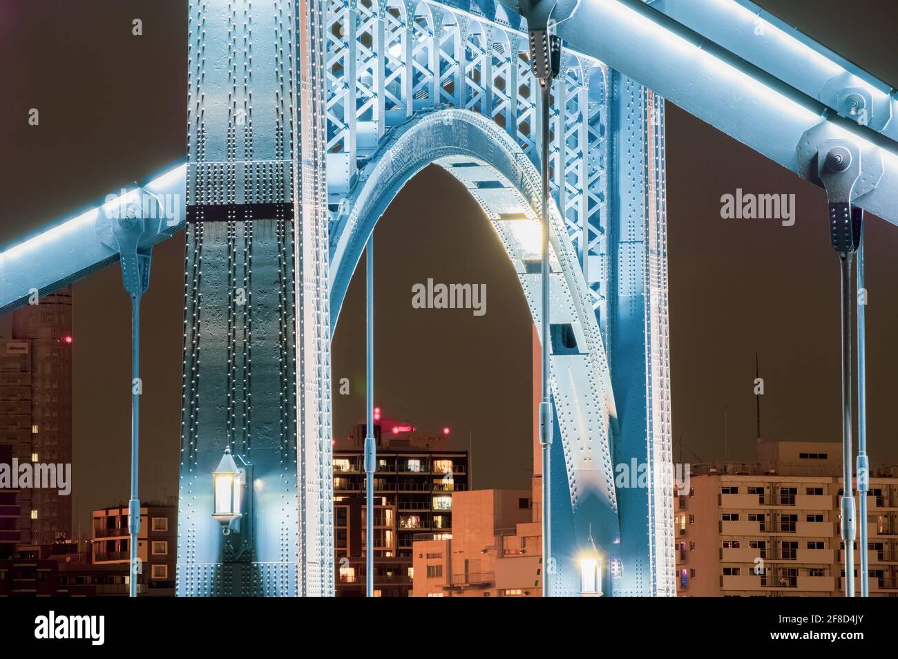 Las luces de los cables principales del puente Kiyosu son montado fuera de la vista debajo de los cables y brillar hacia abajo reflejando la pintura azul del puente Foto de stock