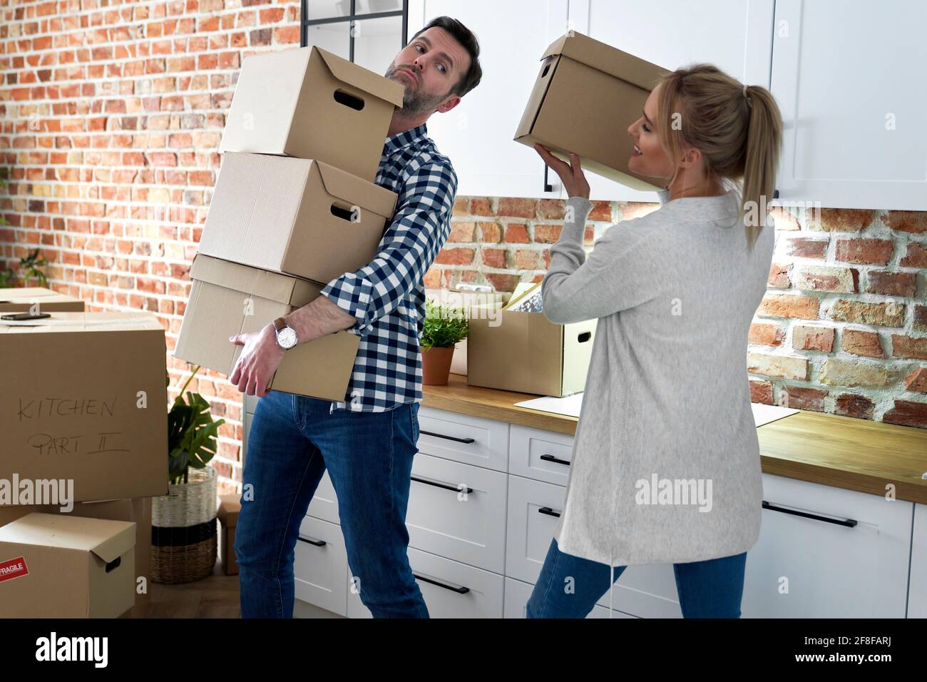 La pareja durante el movimiento hacia fuera toma cajas de cartón Foto de stock