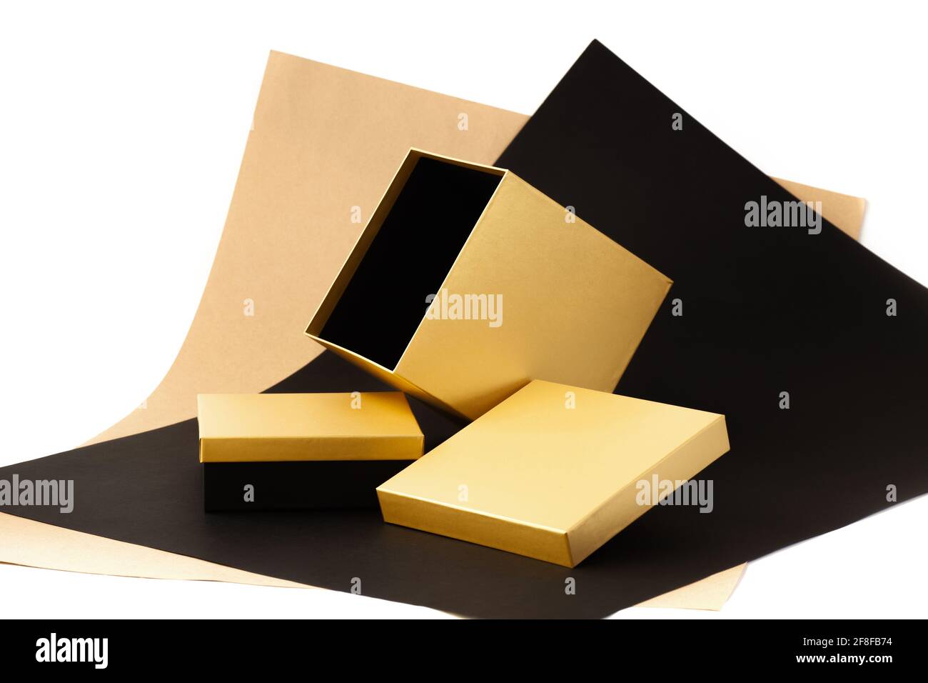 un juego de cajas de regalo minimalistas, caja grande abierta de oro  brillante sobre un fondo de papel beige, negro y blanco Fotografía de stock  - Alamy