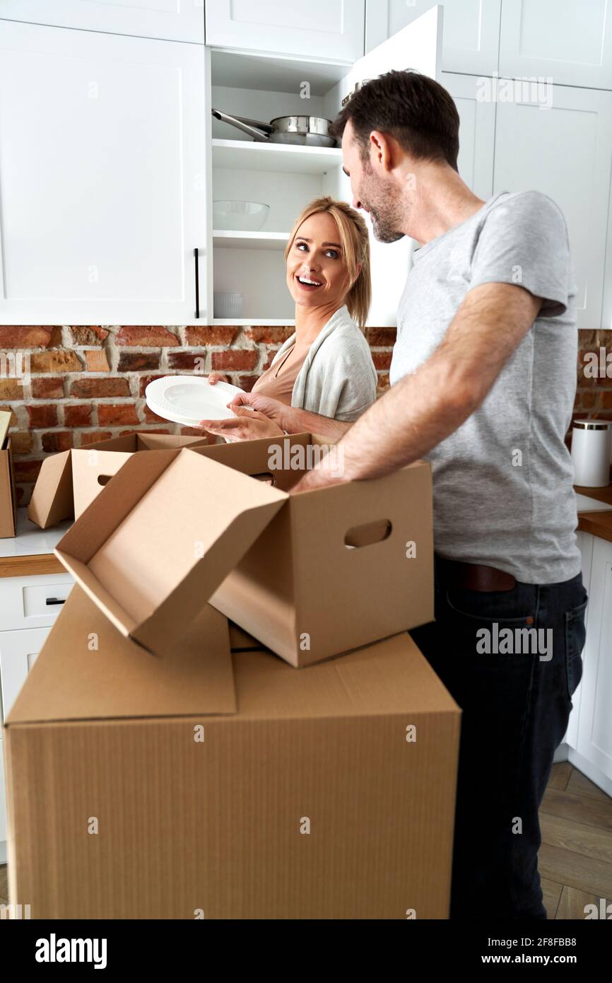 La pareja durante un paquete de movimiento sus cosas en cajas de cartón Foto de stock