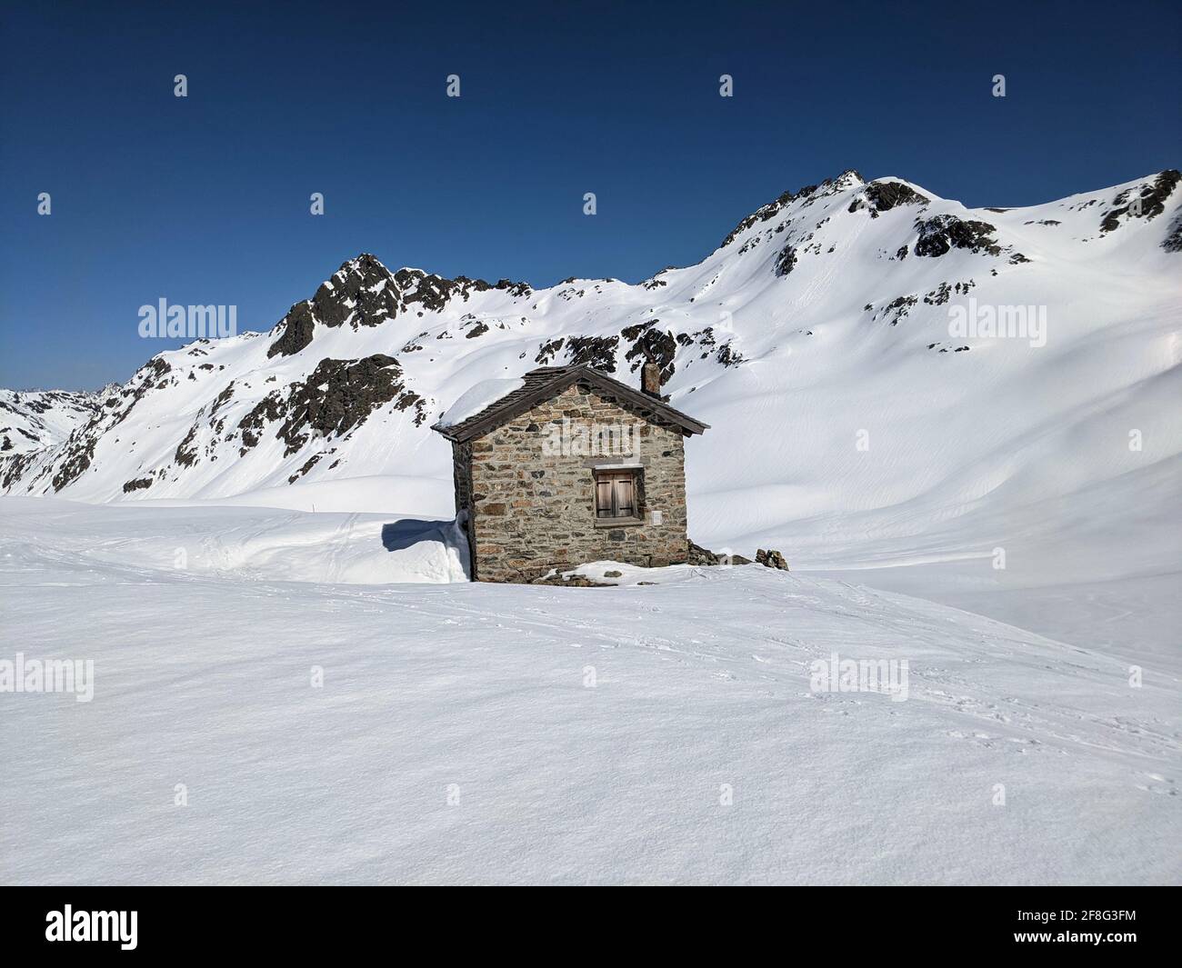 antigua caseta de aduanas entre la frontera austriaca y suiza en el paso del plásseggenpass. Sunny ski tour en las montañas. Cielo azul Foto de stock