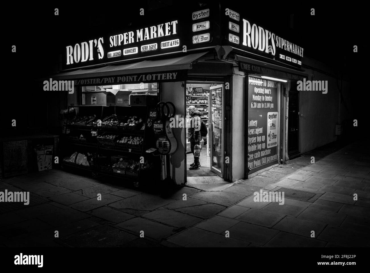 tradicional tienda de esquina, agencia de noticias y tienda de conveniencia en la noche de londres, imagen nocturna en blanco y negro Foto de stock