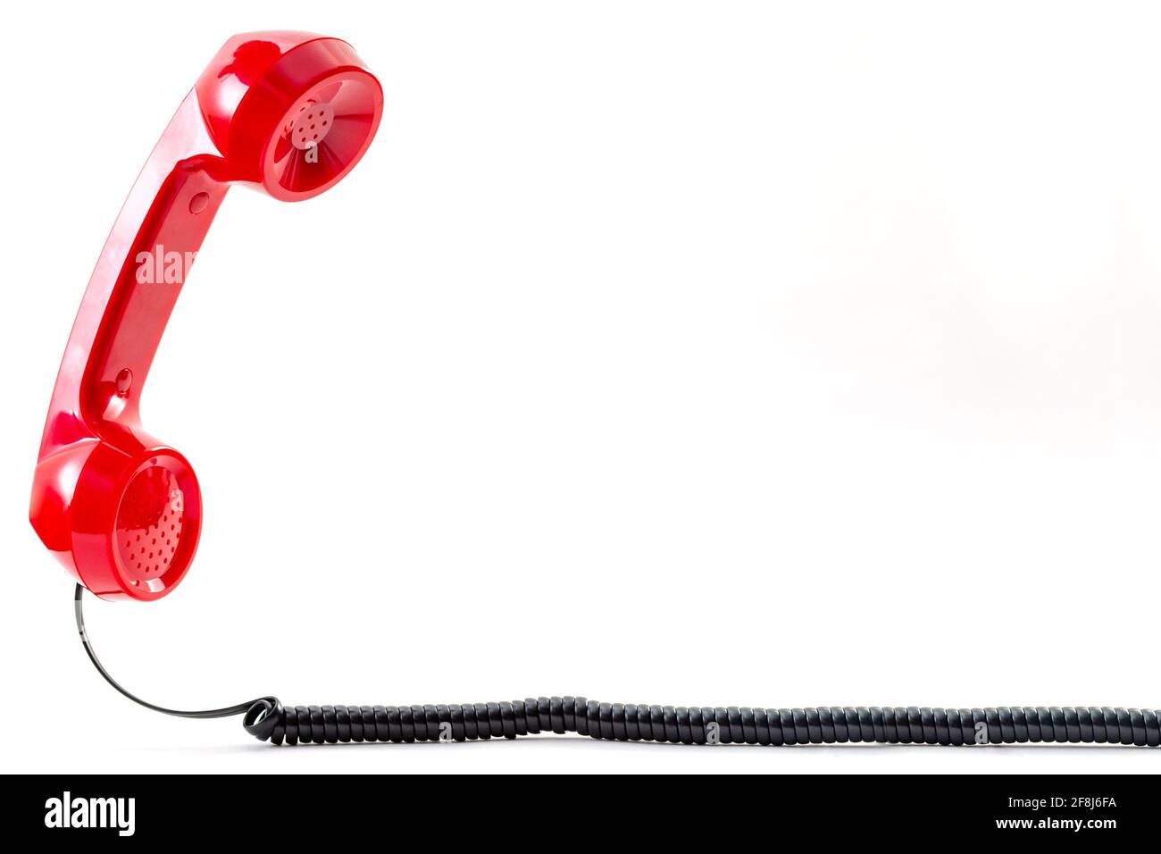 Contacte con nosotros concepto y teléfono flotante receptor con una vendimia microteléfono rojo flotando sobre el cable rizado aislado fondo blanco con c Foto de stock