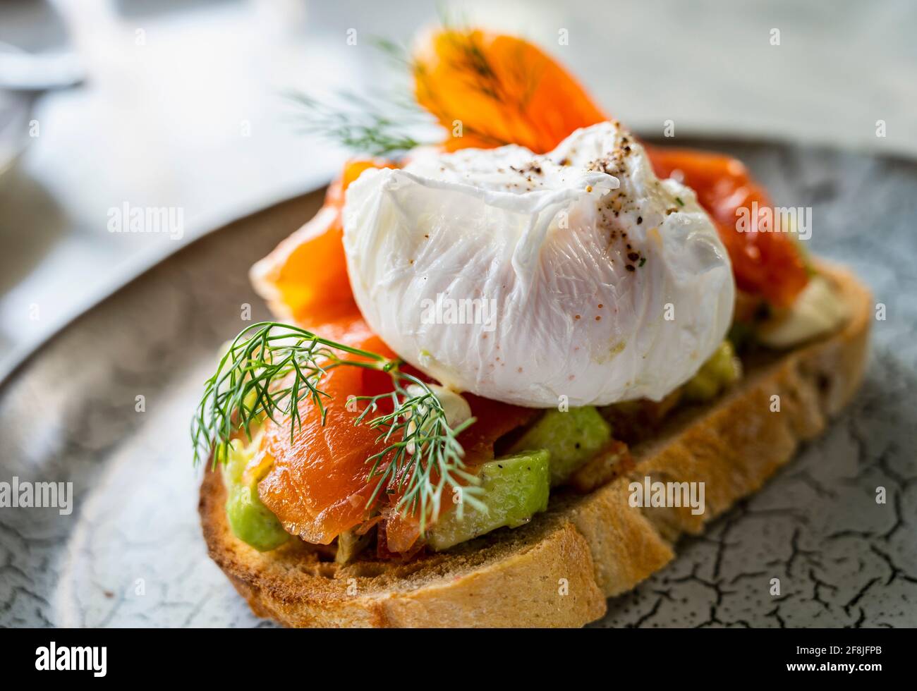 Bruschetta de salmón con aguacate y huevo escalfado Foto de stock
