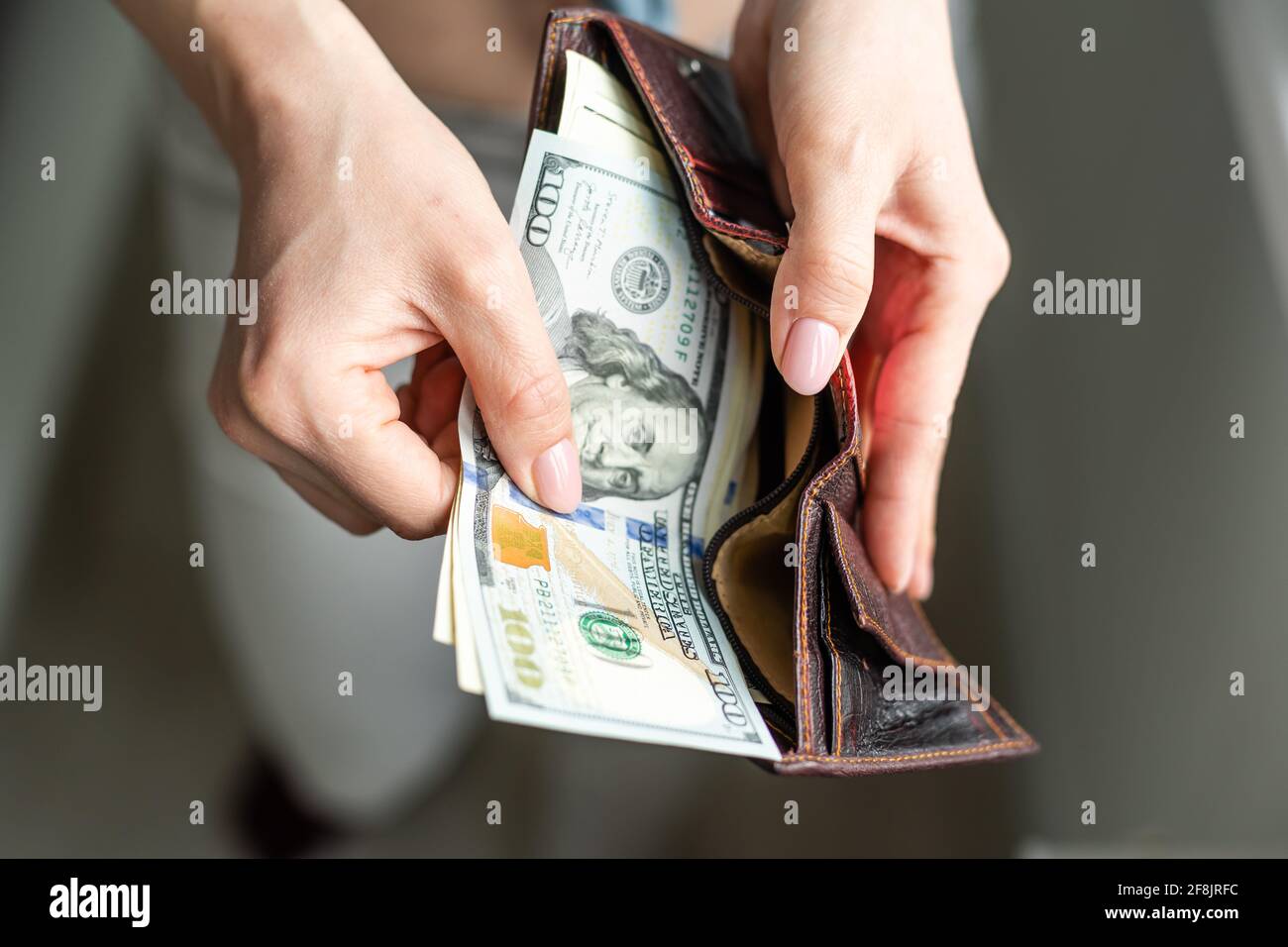 Mujer rica tomando del dinero del bolso Foto de stock
