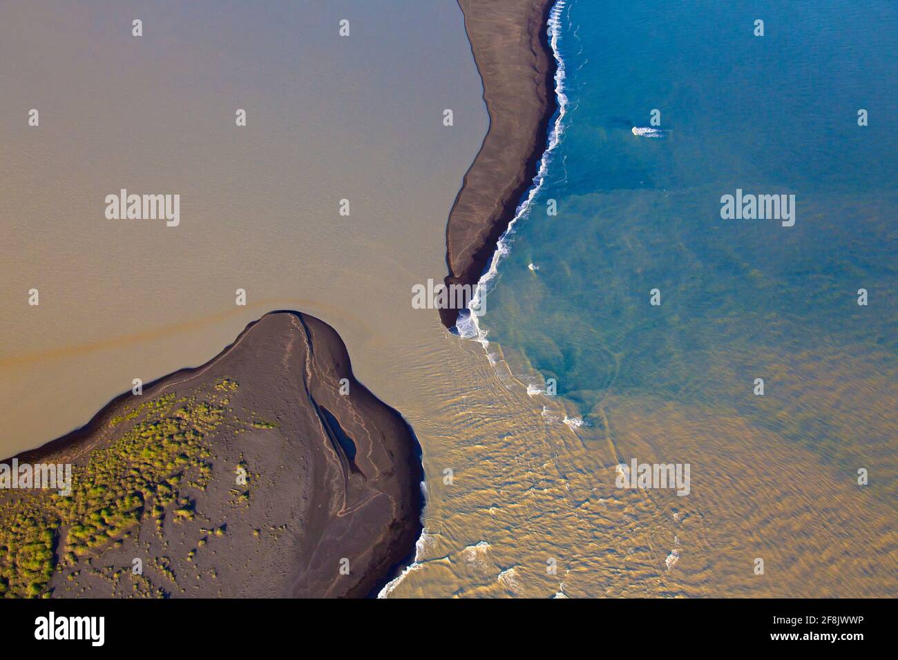Vista aérea sobre Landeyjarsandur mostrando la playa con arena volcánica negra y agua marrón cargada de sedimentos que fluyen en el mar en verano, Islandia Foto de stock