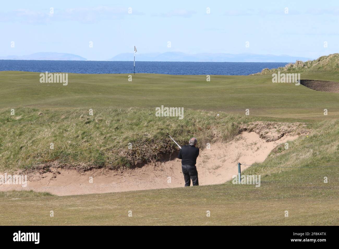 Scotland, Ayrshire Turnberry Golf Ailsa Course 12 de abril de 2021. El agujero de 10th conocido como Dinna Fouter. Golfista en búnker Foto de stock