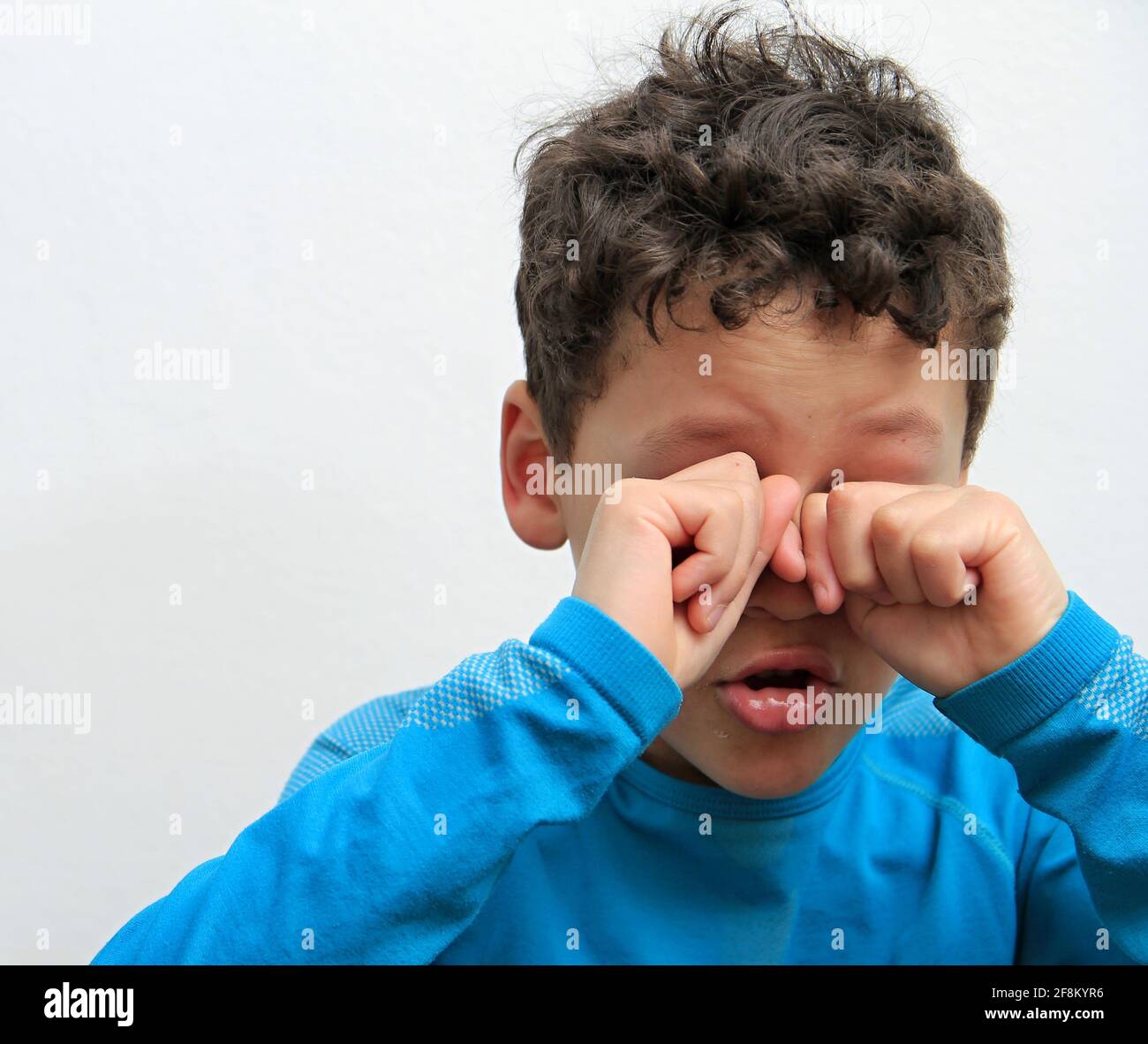 niño llorando con la mano sobre la cara llorando solo y todo por sí