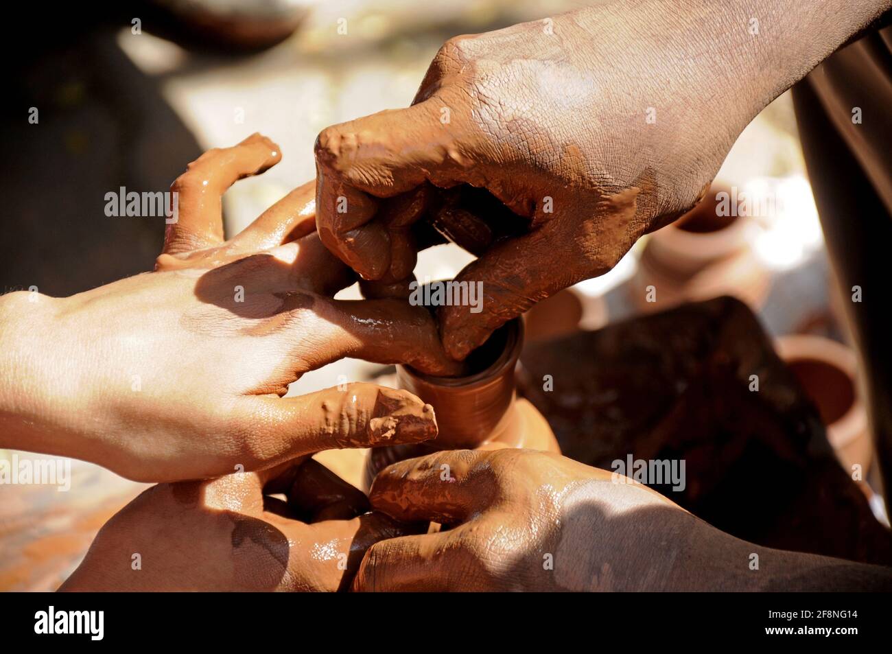 Maestro y niño haciendo cerámica en la rueda de cerámica Foto de stock