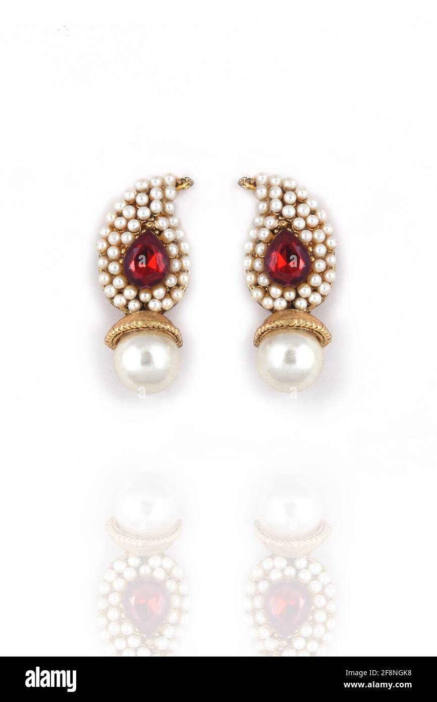 Hermoso par de pendientes perla con piedra preciosa roja sobre un fondo blanco joyería tradicional India, , pendientes de oro nupcial joyas de boda Foto de stock