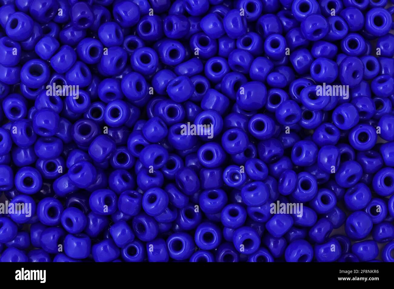 Cuentas azules sobre el fondo blanco primer plano, macro, hacer collar de abalorios Foto de stock